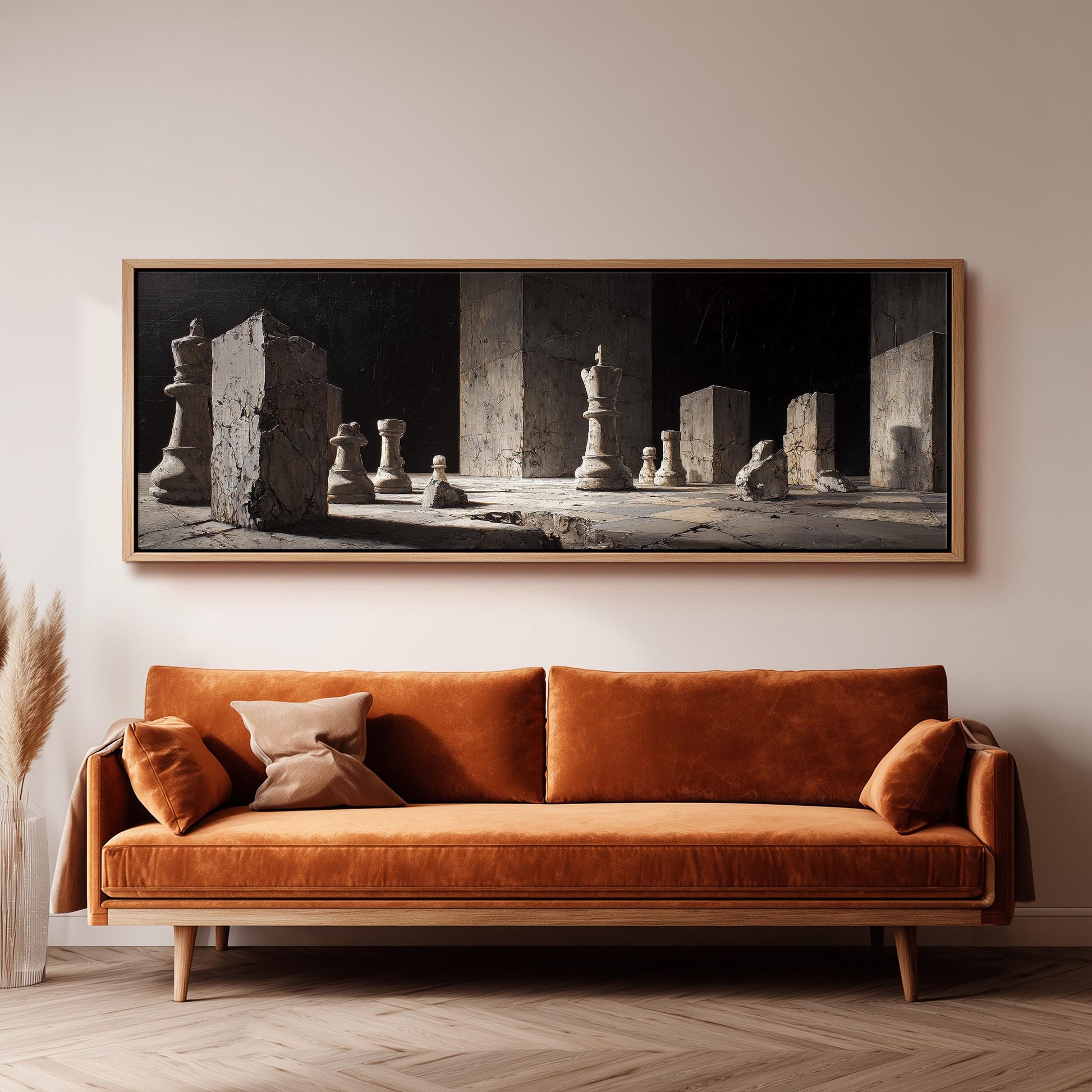 a large black and white painting of chess pieces on a wall above a brown sofa with orange cushions.