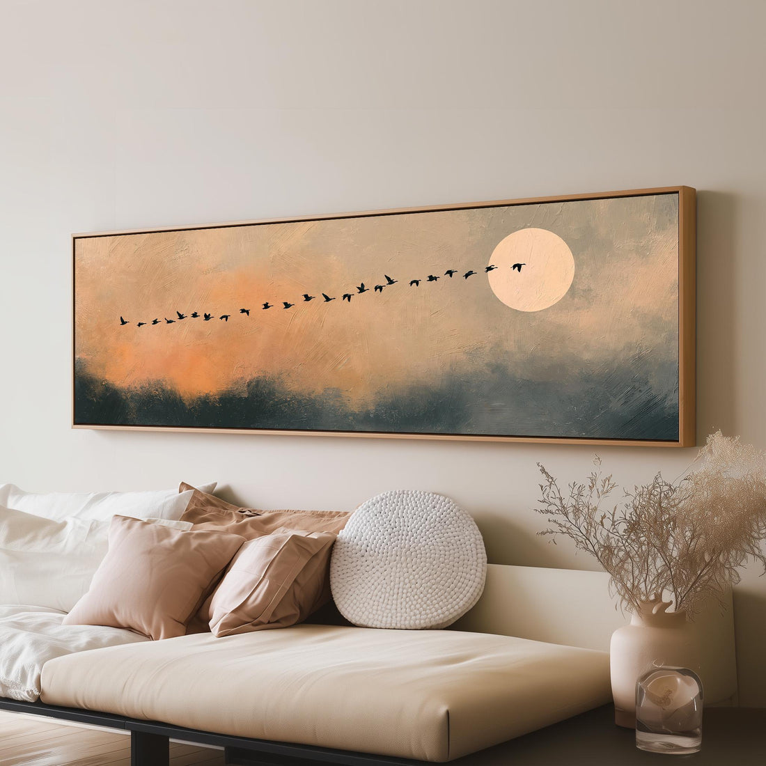 Migrating birds passing a moon at peach dusk long horizontal canvas print above a sofa in a living room