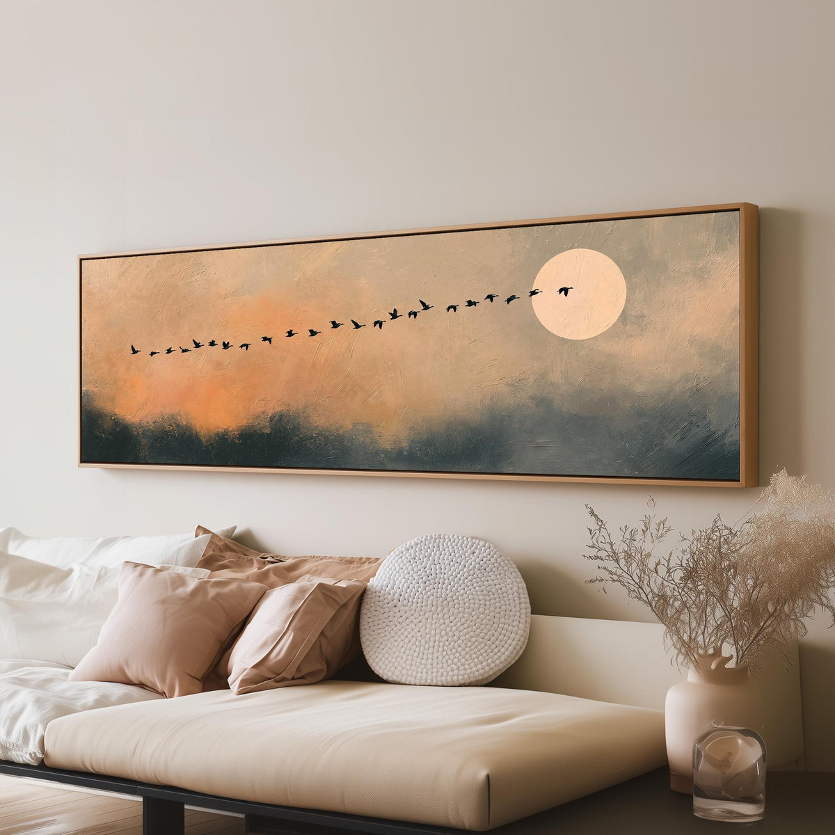 Migrating birds passing a moon at peach dusk panoramic canvas print above a sofa in a living room
