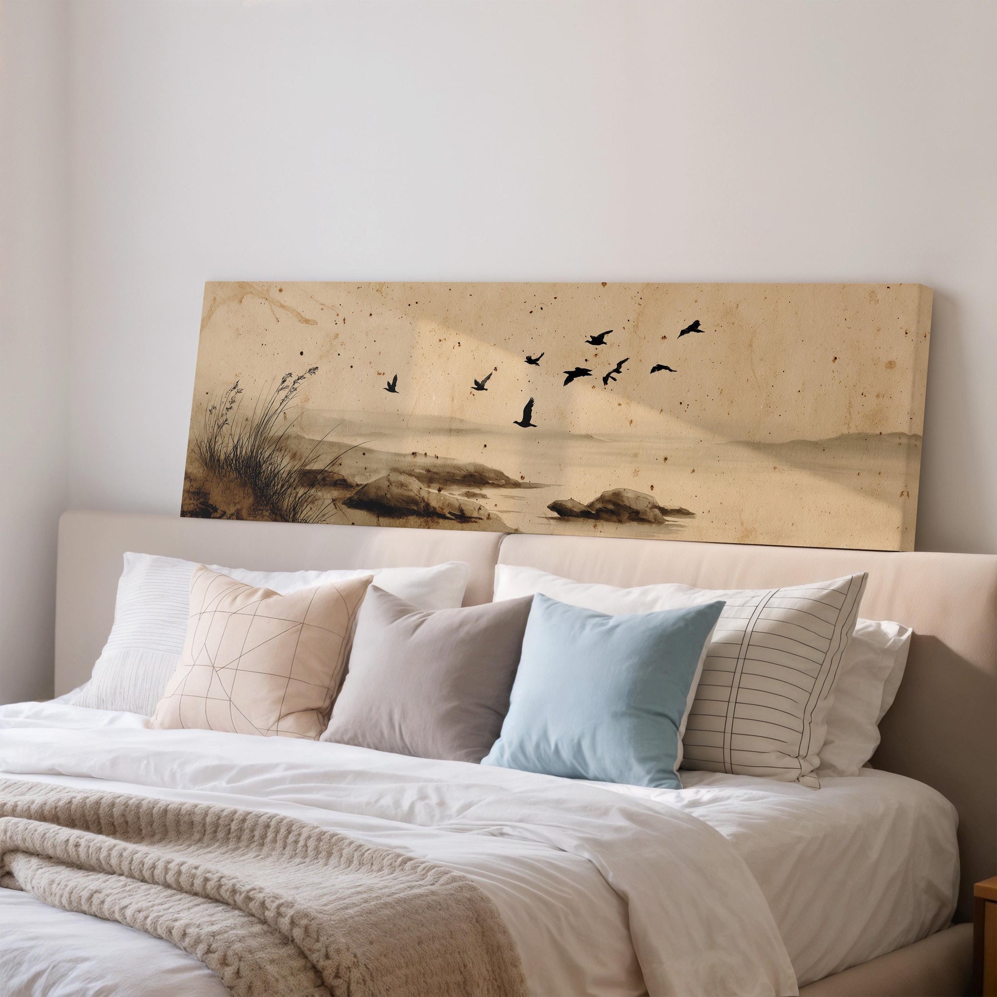 a large painting of birds flying over a landscape, displayed on a wall above a bed with white bedding and pillows.