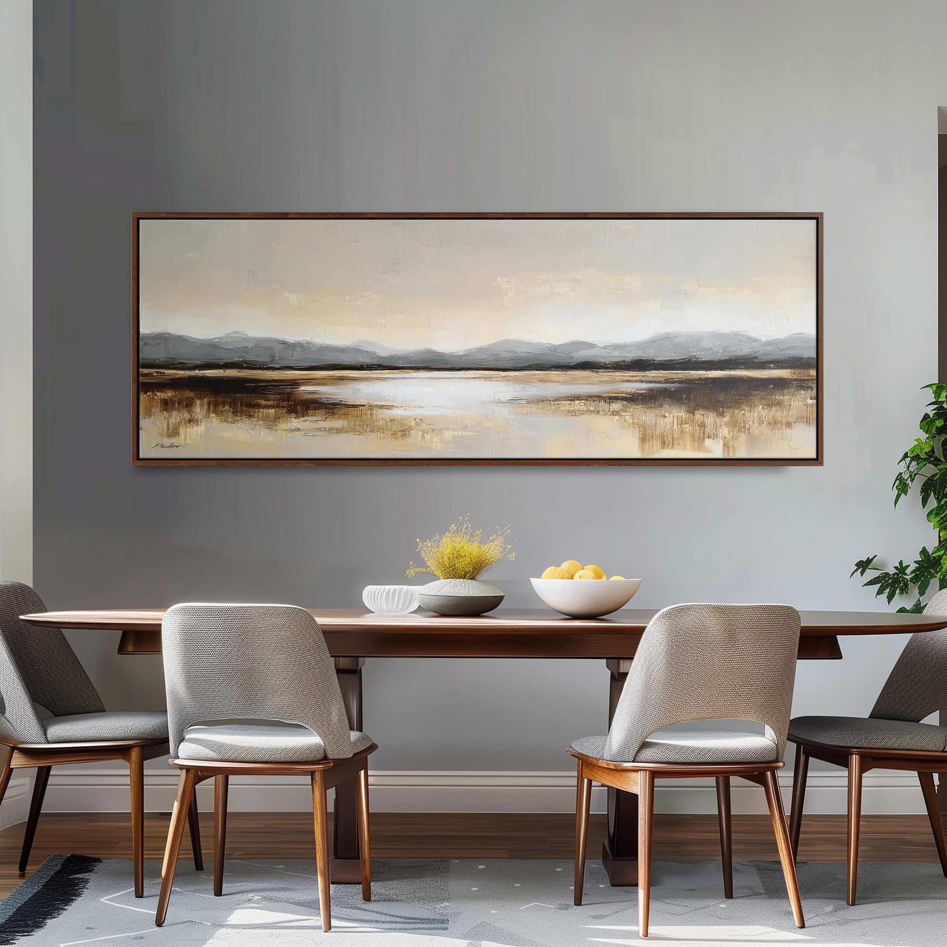 a dining room with a large painting of a landscape hanging on the wall above a wooden dining table with four chairs. The table is set with a bowl of fruit and a vase of flowers, creating a cozy and inviting atmosphere.