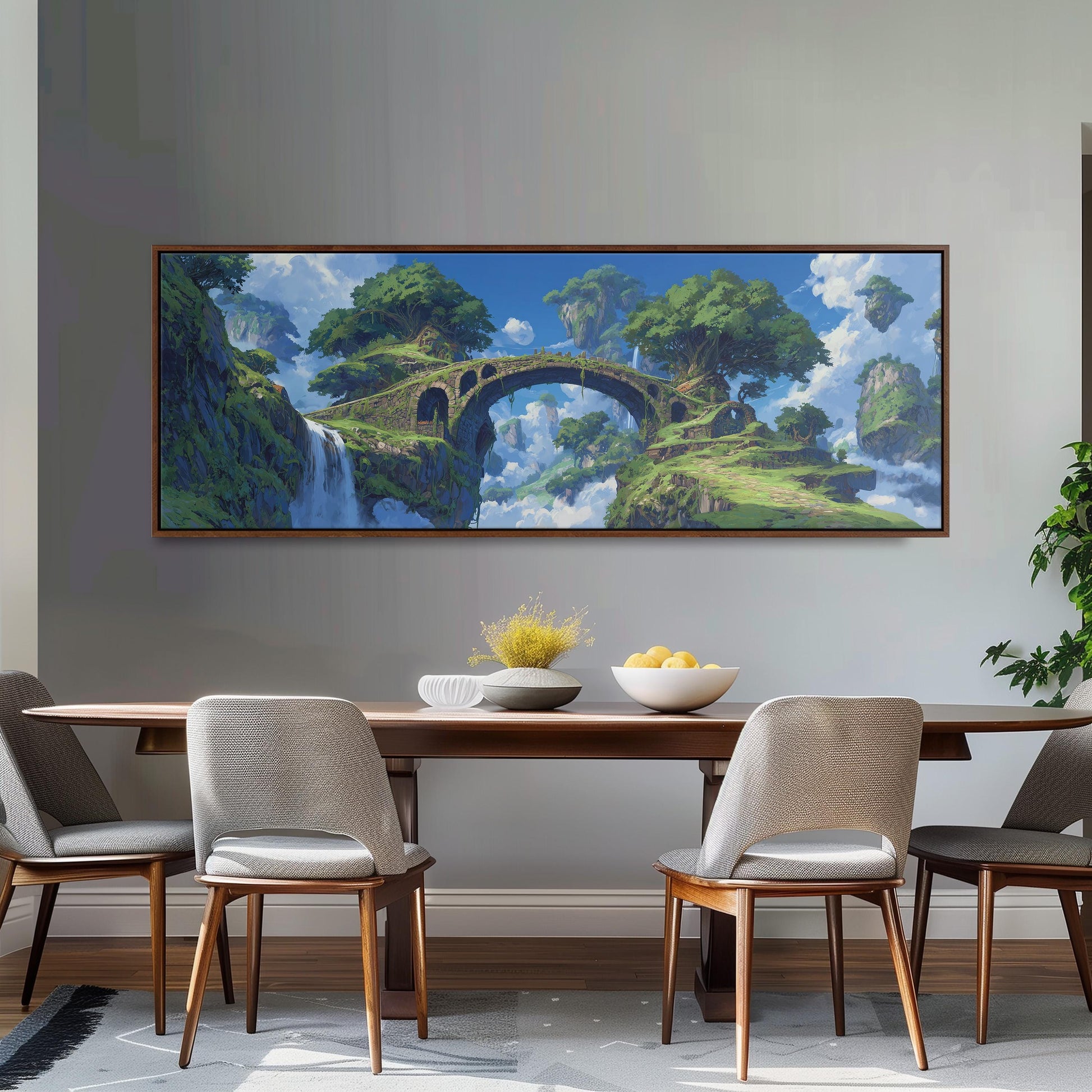 a large painting of a bridge over a waterfall, with a lush, green landscape and a blue sky in the background. The painting is hung on a wall above a wooden dining table with four chairs around it. The table is set with a bowl of fruit and a vase of flowers, creating a cozy and inviting atmosphere.