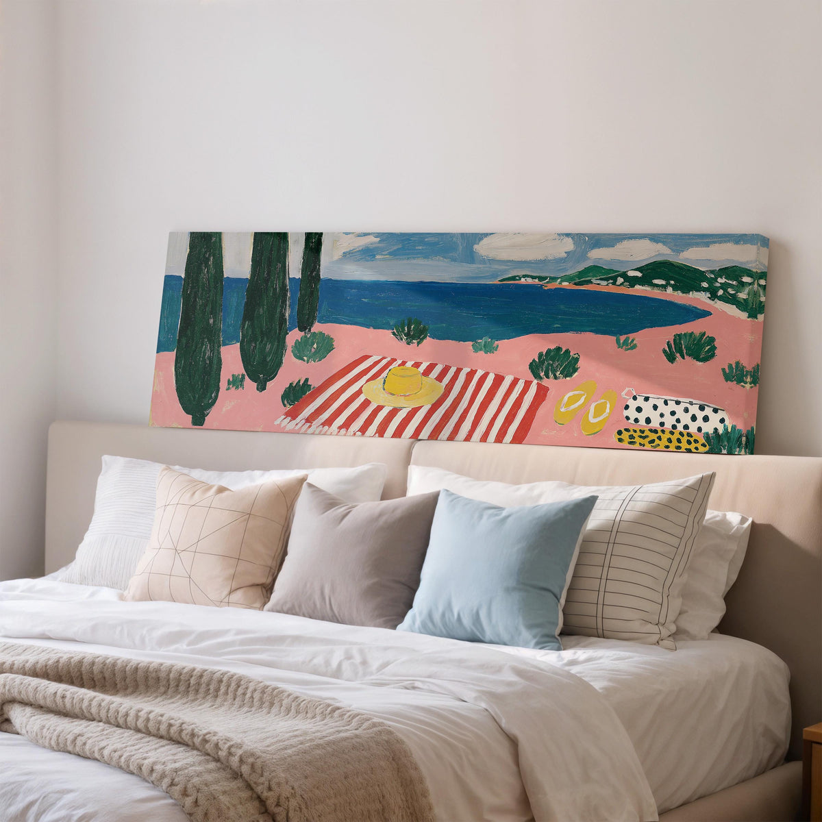 Mediterranean beach day with a striped towel wide panoramic canvas print above a bed in a bedroom