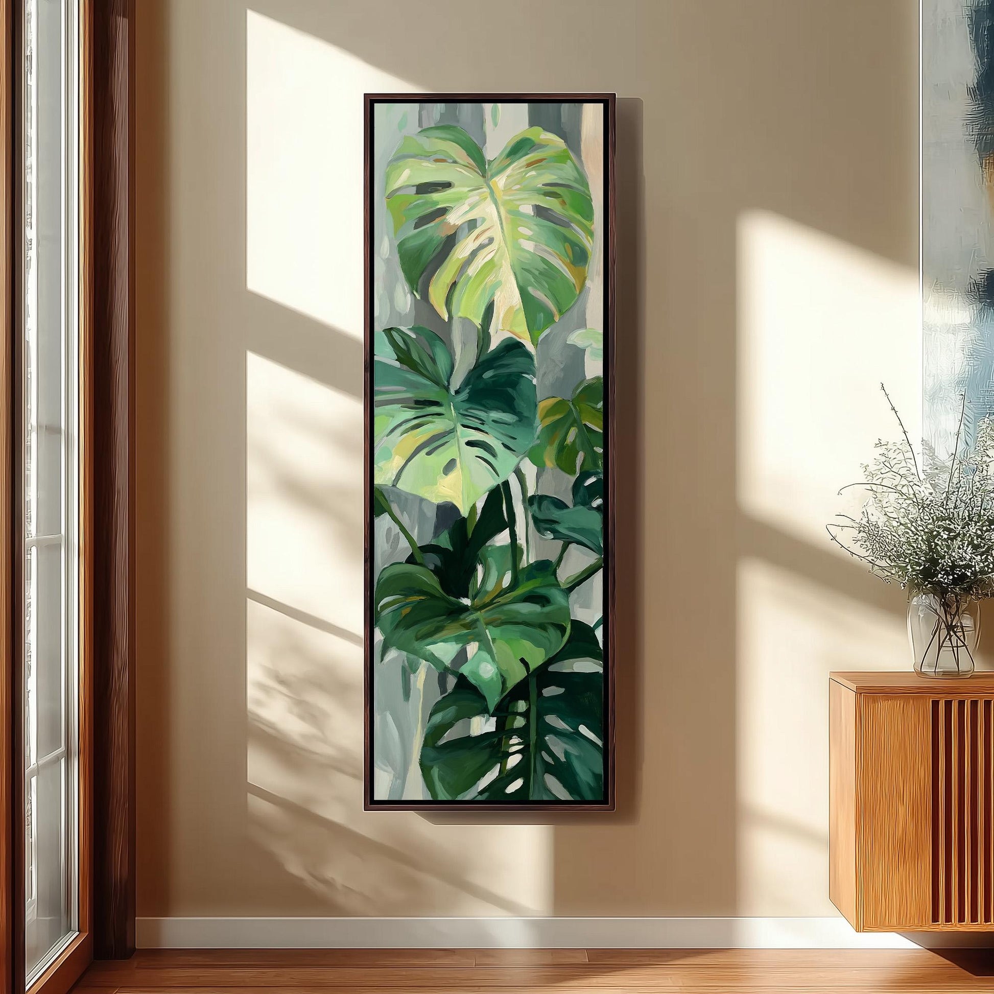 a large painting of a tropical plant hanging on a wall in a room with a wooden cabinet and a vase of flowers.
