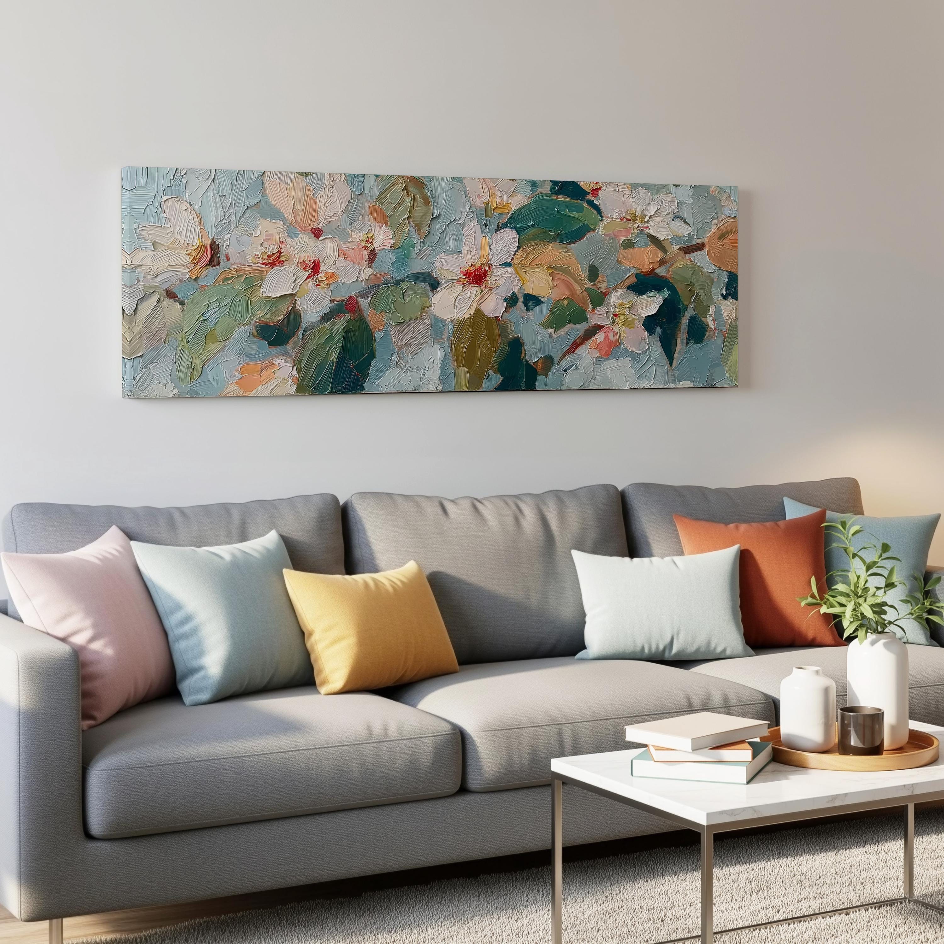a cozy living room with a gray sofa adorned with colorful throw pillows, a white coffee table, and a large painting of flowers hanging on the wall above the sofa.