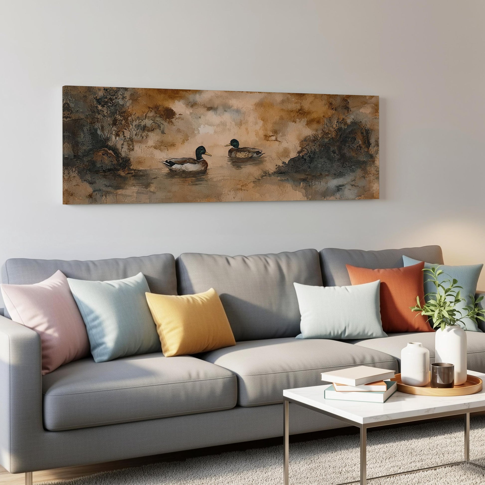 a gray couch with colorful throw pillows, a coffee table, and a painting of ducks on the wall above it.