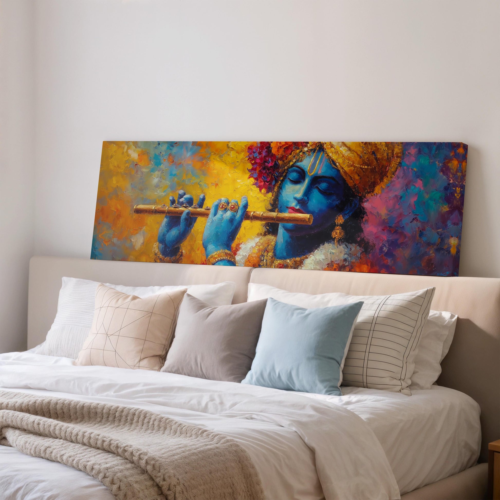 a large painting of a blue-skinned Hindu deity playing a flute, displayed on a wall above a bed with white pillows and a gray blanket.