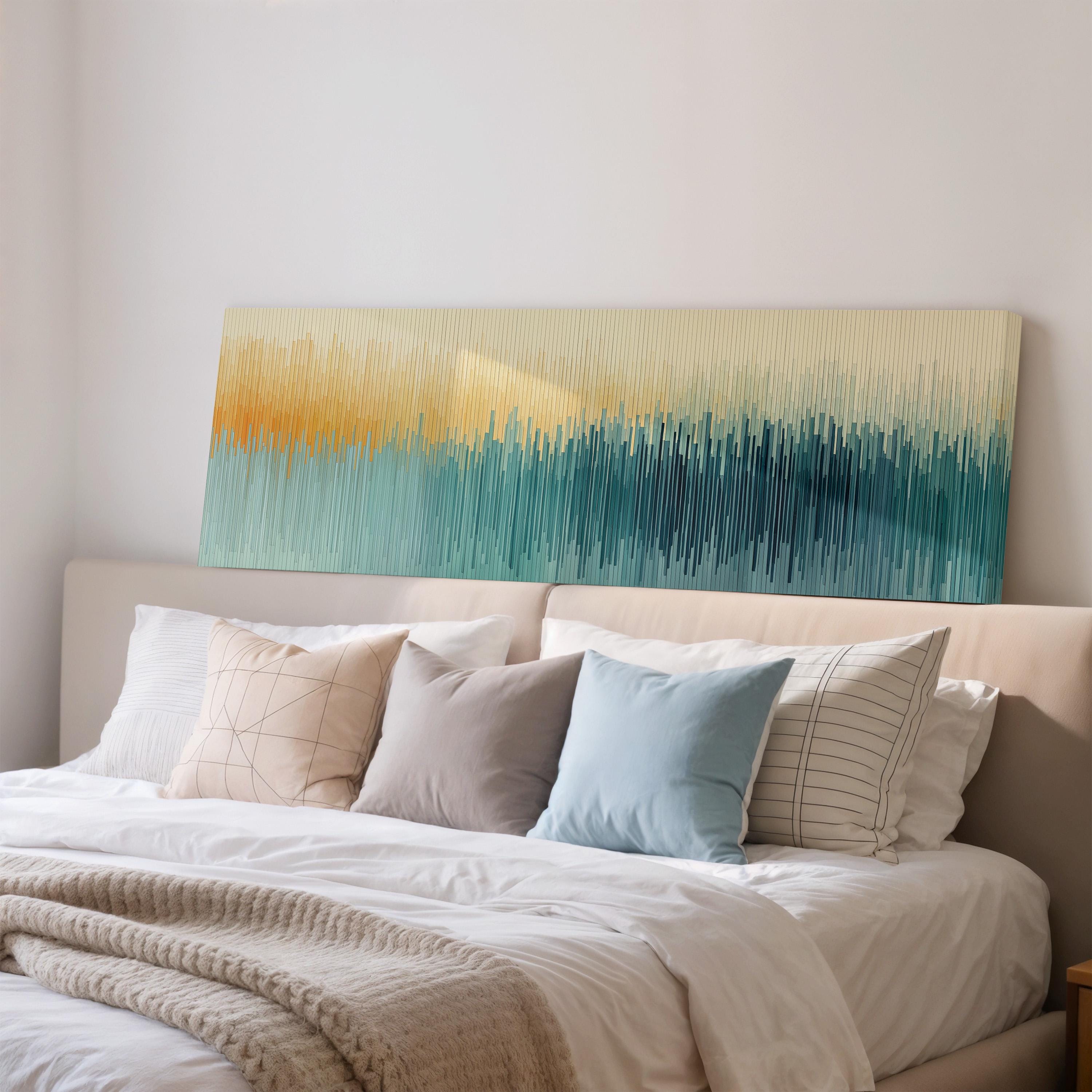 a cozy bedroom with a large bed adorned with white linens and a variety of colorful throw pillows. Above the bed, there is a large abstract painting with a gradient of colors, creating a vibrant and visually appealing focal point in the room.