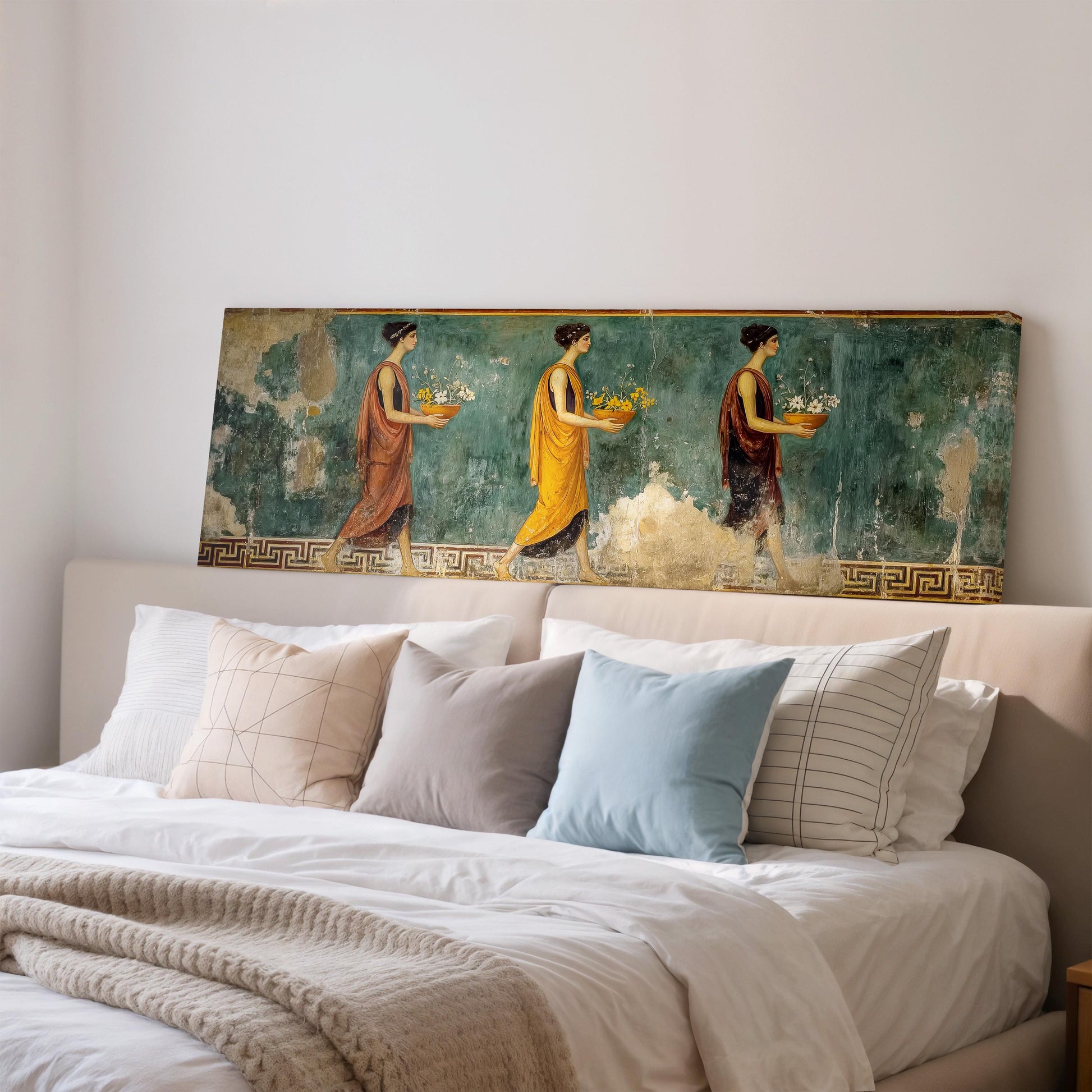 a large painting of three women, each holding a basket of fruit, displayed on a wall above a bed with white bedding and pillows.