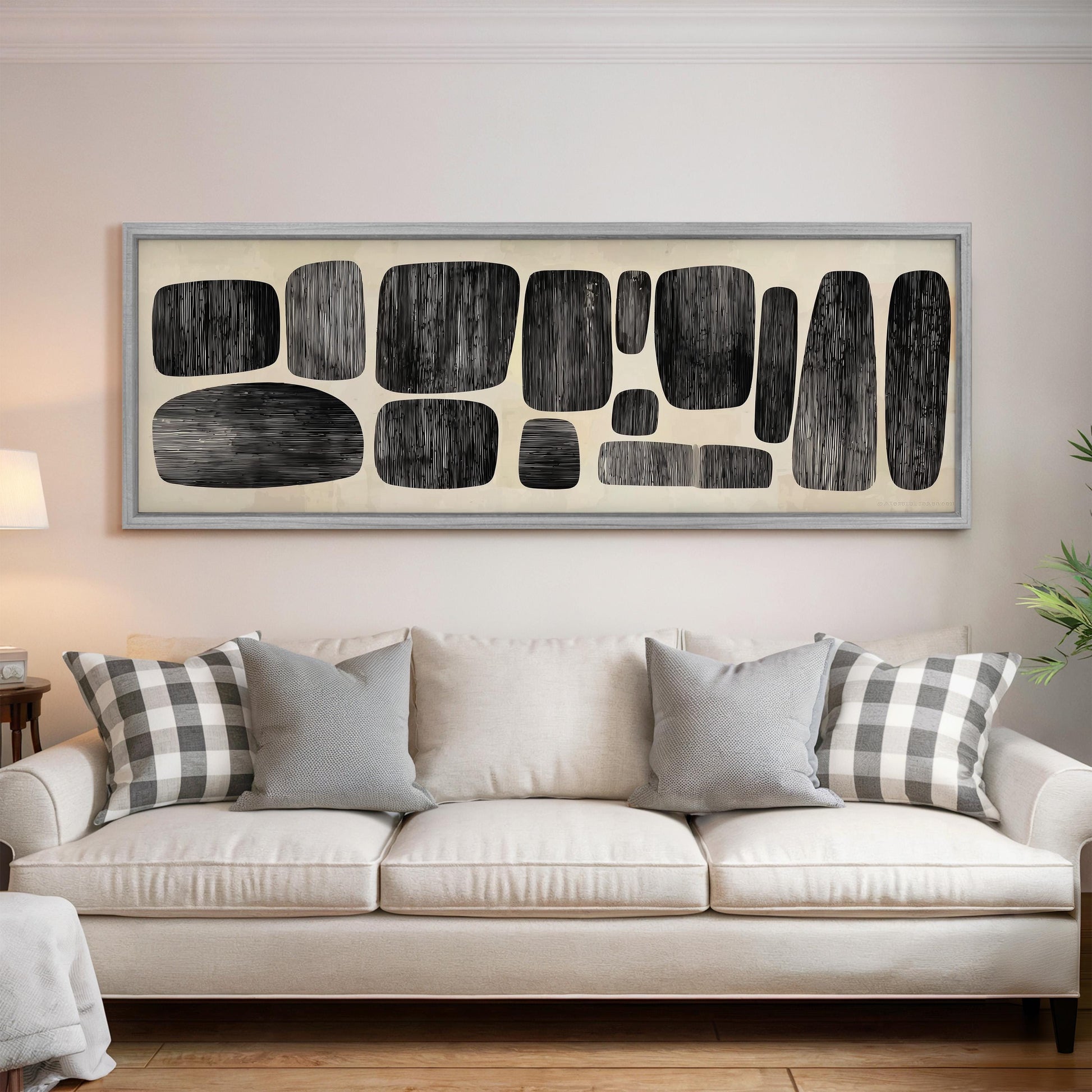 a living room with a white sofa and a large abstract artwork hanging on the wall above it.