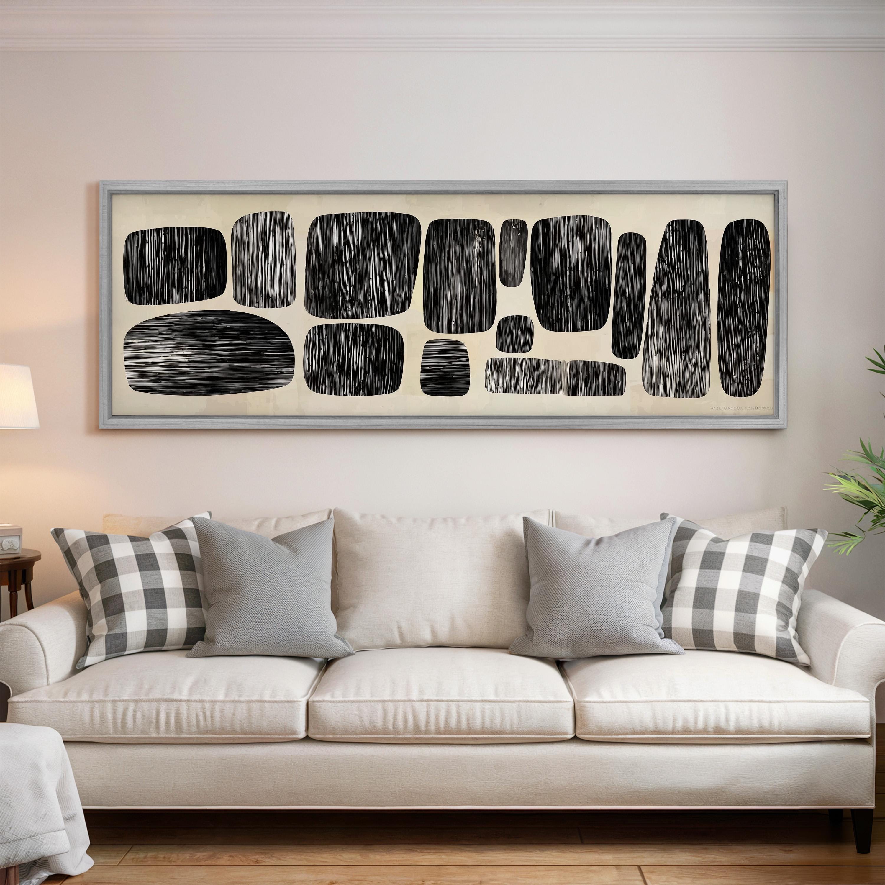 a living room with a white sofa and a large abstract artwork hanging on the wall above it.