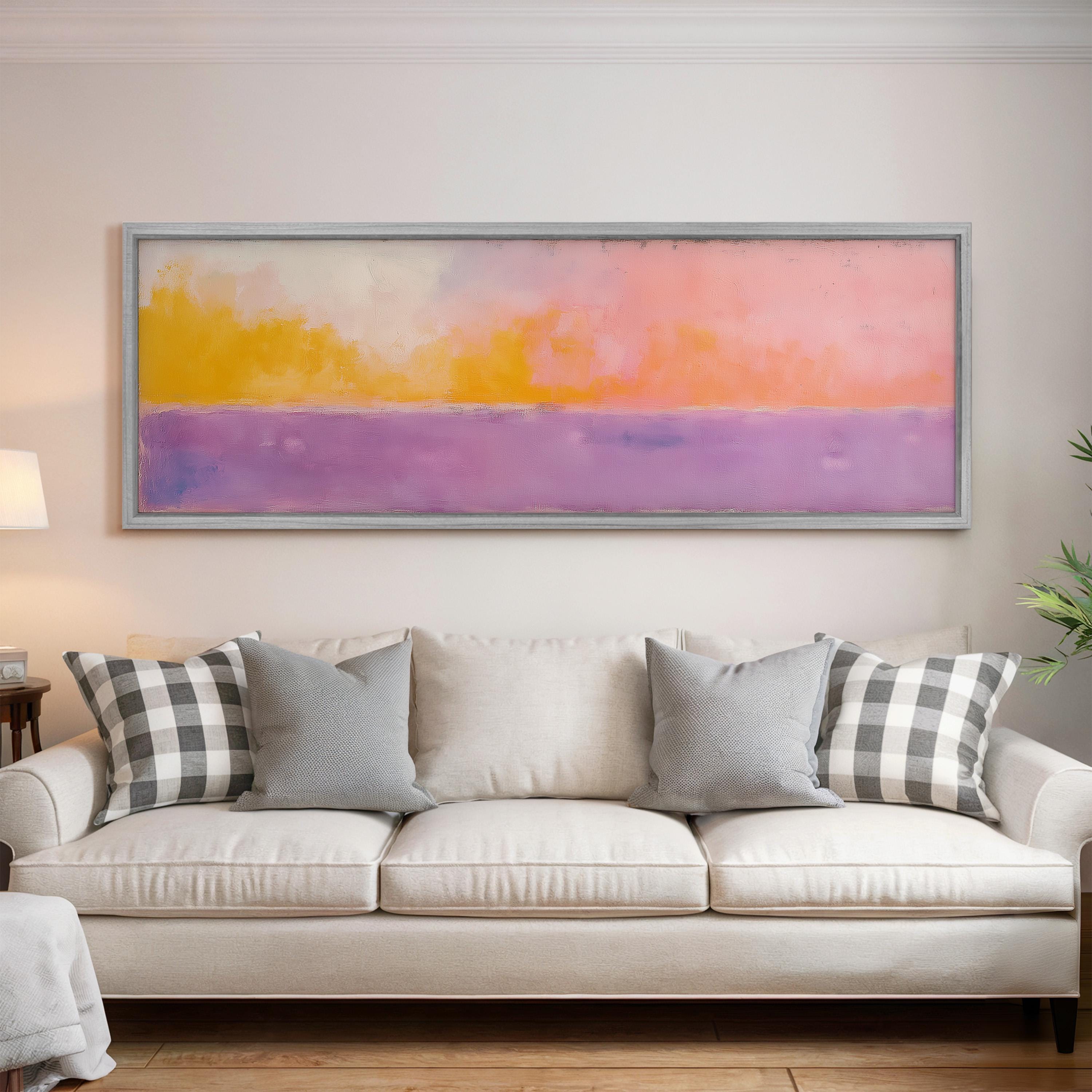 a large, colorful painting hanging on a wall above a white couch with gray and black checkered throw pillows.
