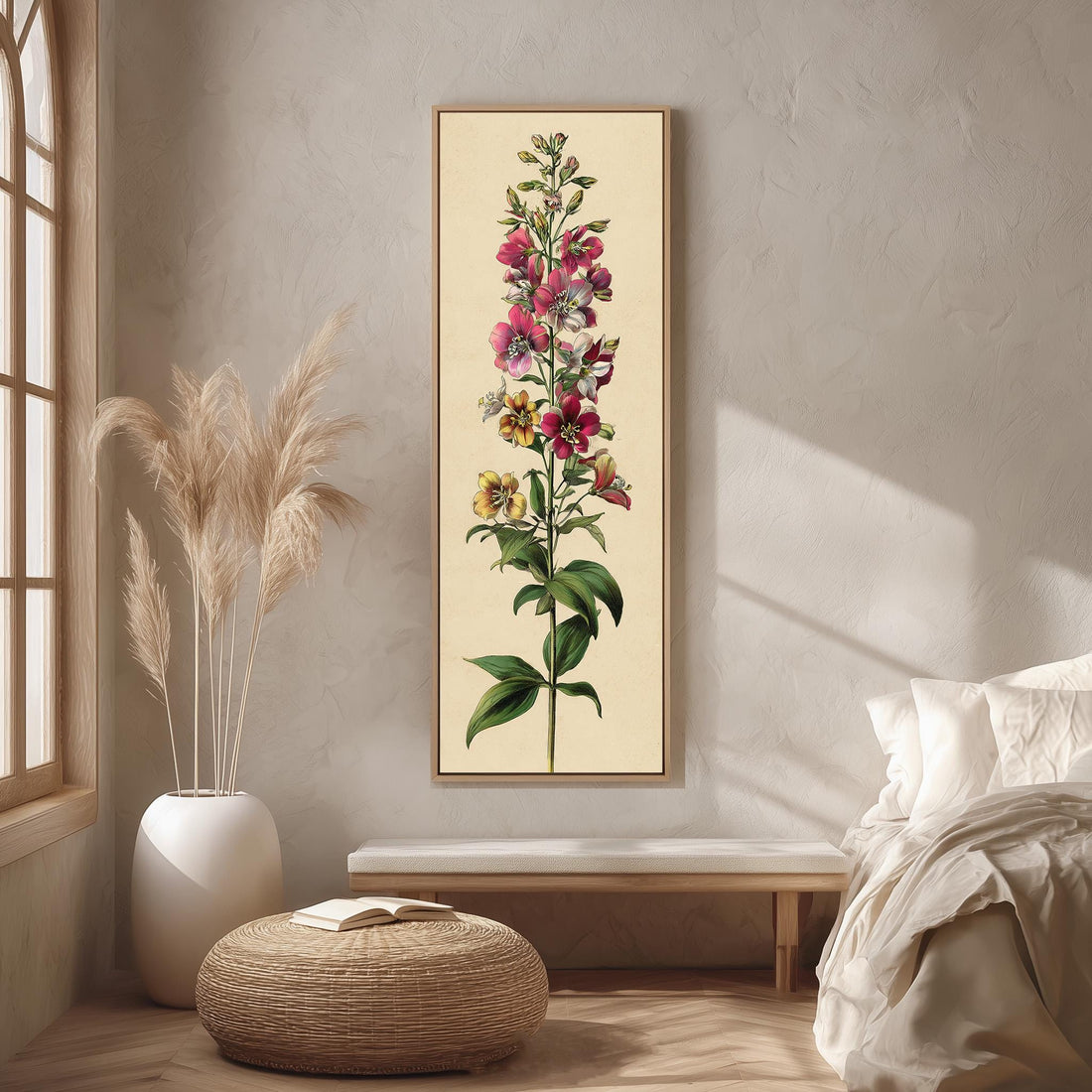 a large framed botanical illustration of a flower on a wall, with a bed, a potted plant, and a woven ottoman in the foreground.