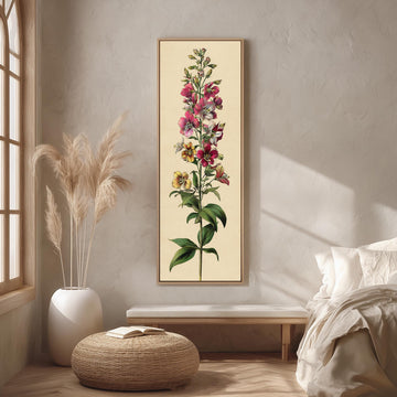 a large framed botanical illustration of a flower on a wall, with a bed, a potted plant, and a woven ottoman in the foreground.