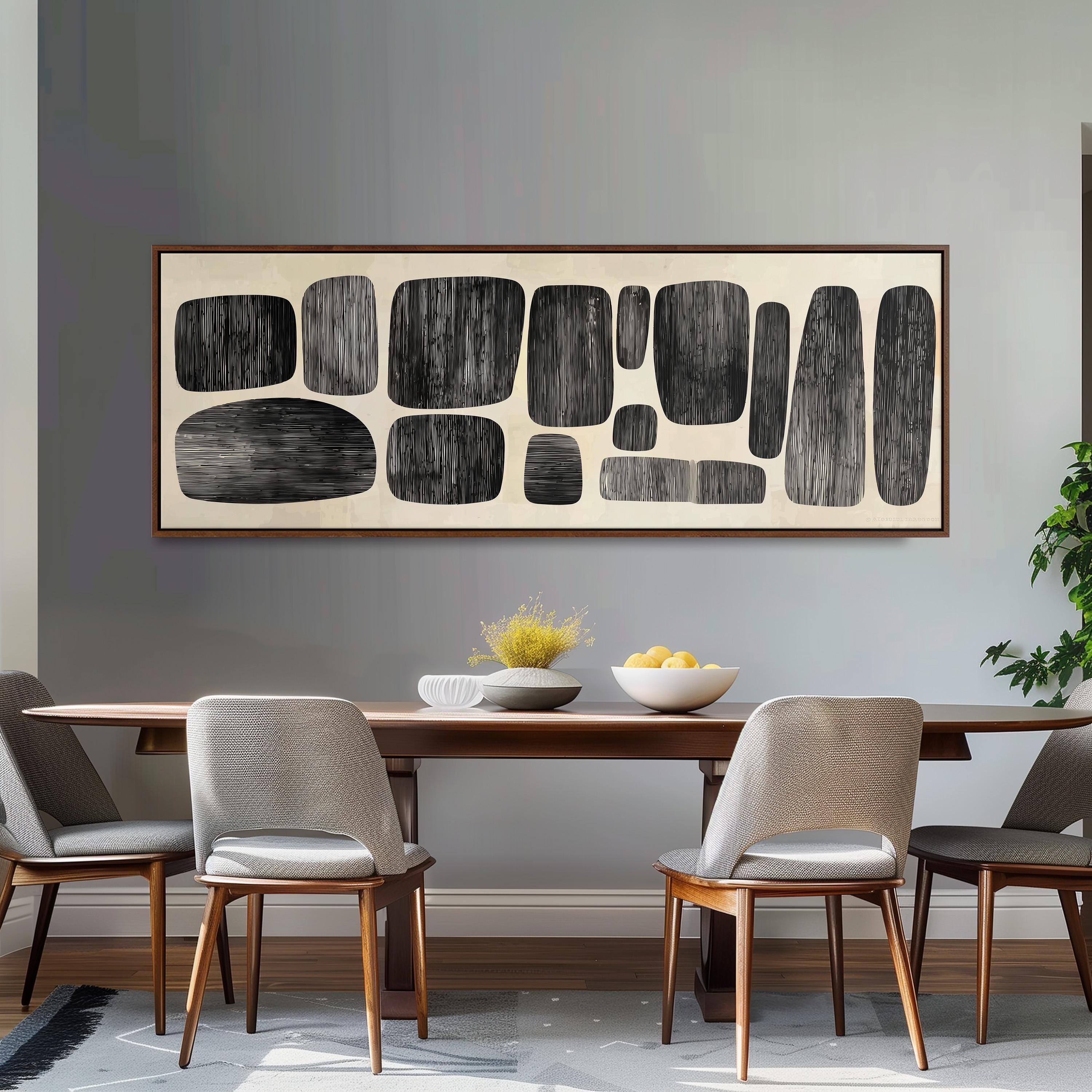 a dining room with a wooden table and four chairs. Above the table, there is a large abstract art piece composed of black and white shapes. The table is set with a bowl of fruit and a vase of flowers, creating a cozy and inviting atmosphere.