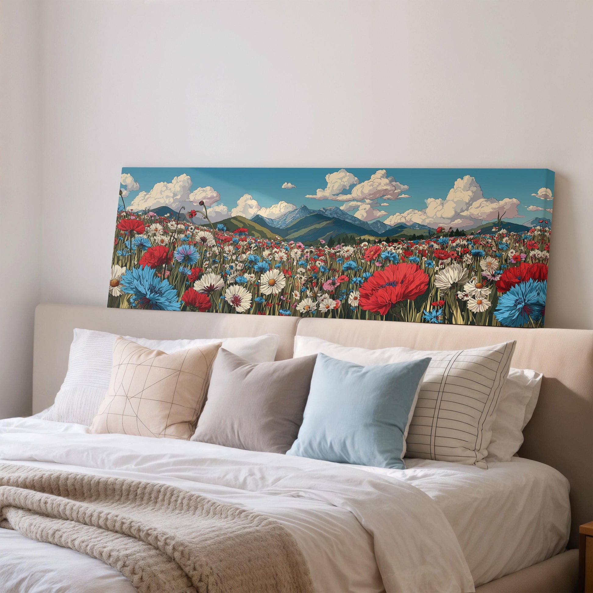 a large canvas print of a colorful field of flowers hanging above a bed with white pillows and a gray blanket.