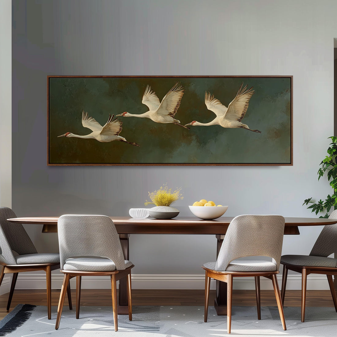 a dining room with a large painting of three white birds in flight above a wooden table. The table is set with a bowl of fruit and a vase of flowers, creating a cozy and inviting atmosphere.