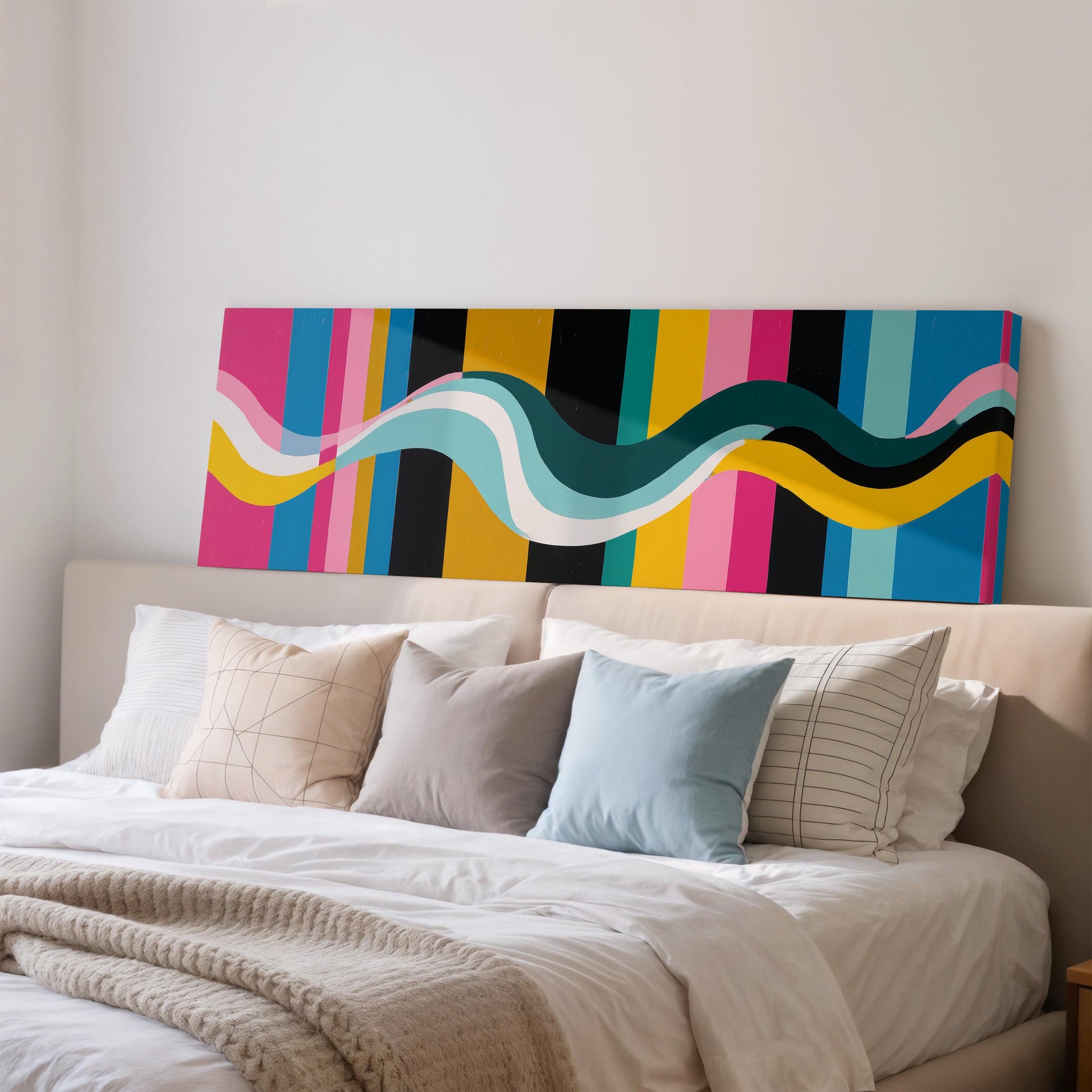 a large bed with a colorful abstract painting hanging above it.