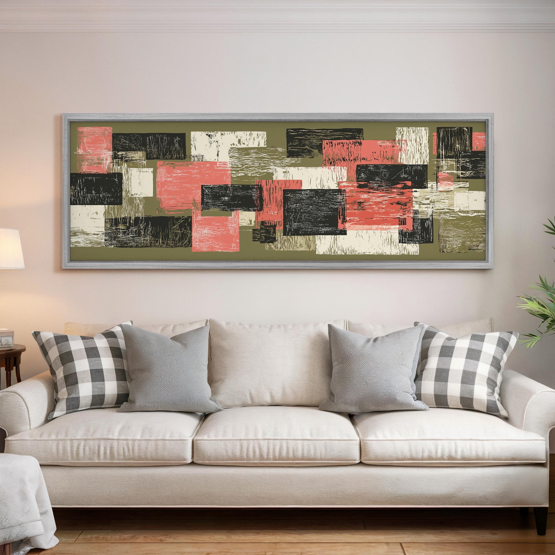 a large abstract painting hanging on a wall above a white couch with gray and black plaid throw pillows.