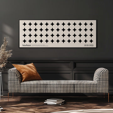 a modern black and white checkered sofa with a brown throw pillow, set against a dark wall with a framed poster above it.