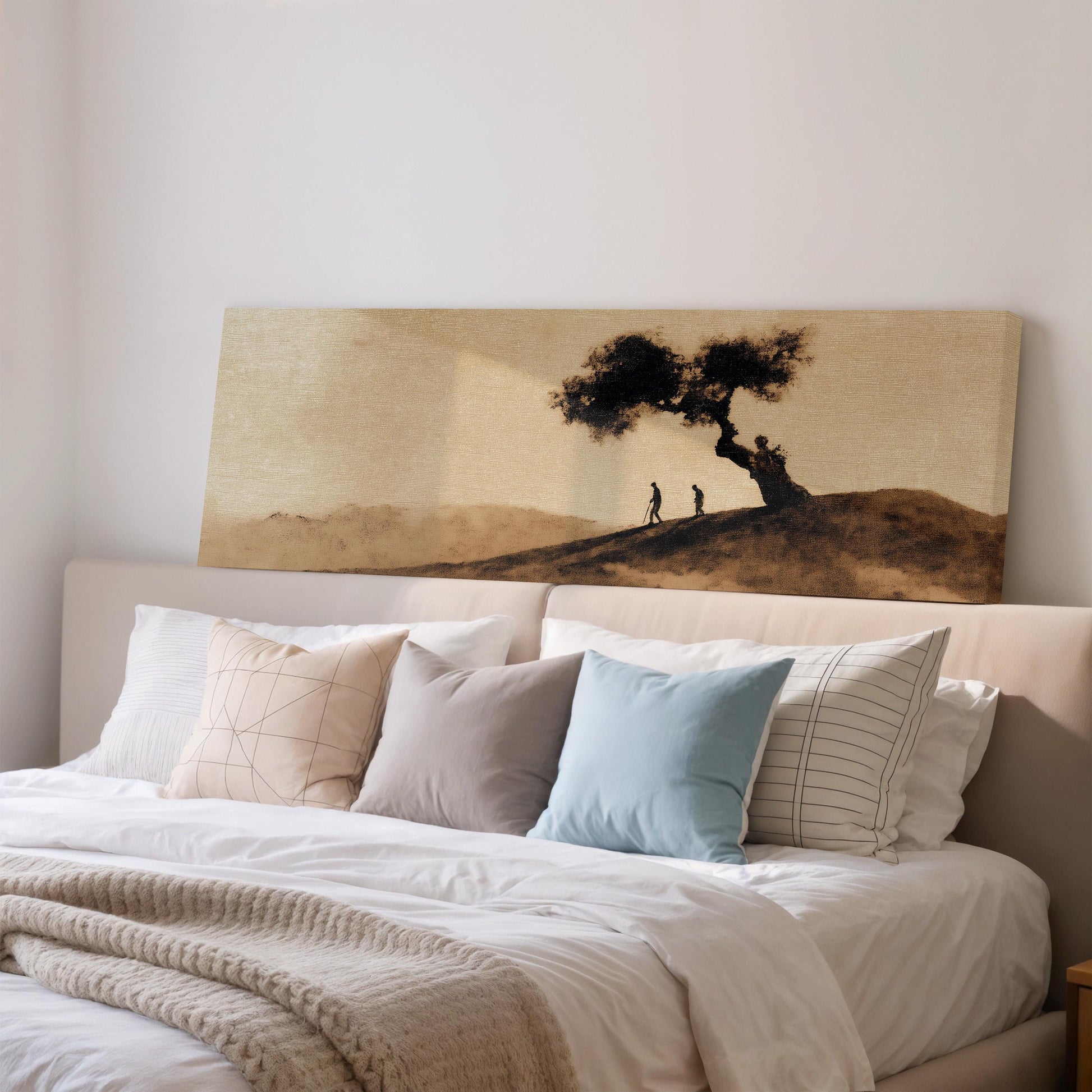 a large bed with a white comforter and pillows, and a painting of a tree and two people on the wall above it.