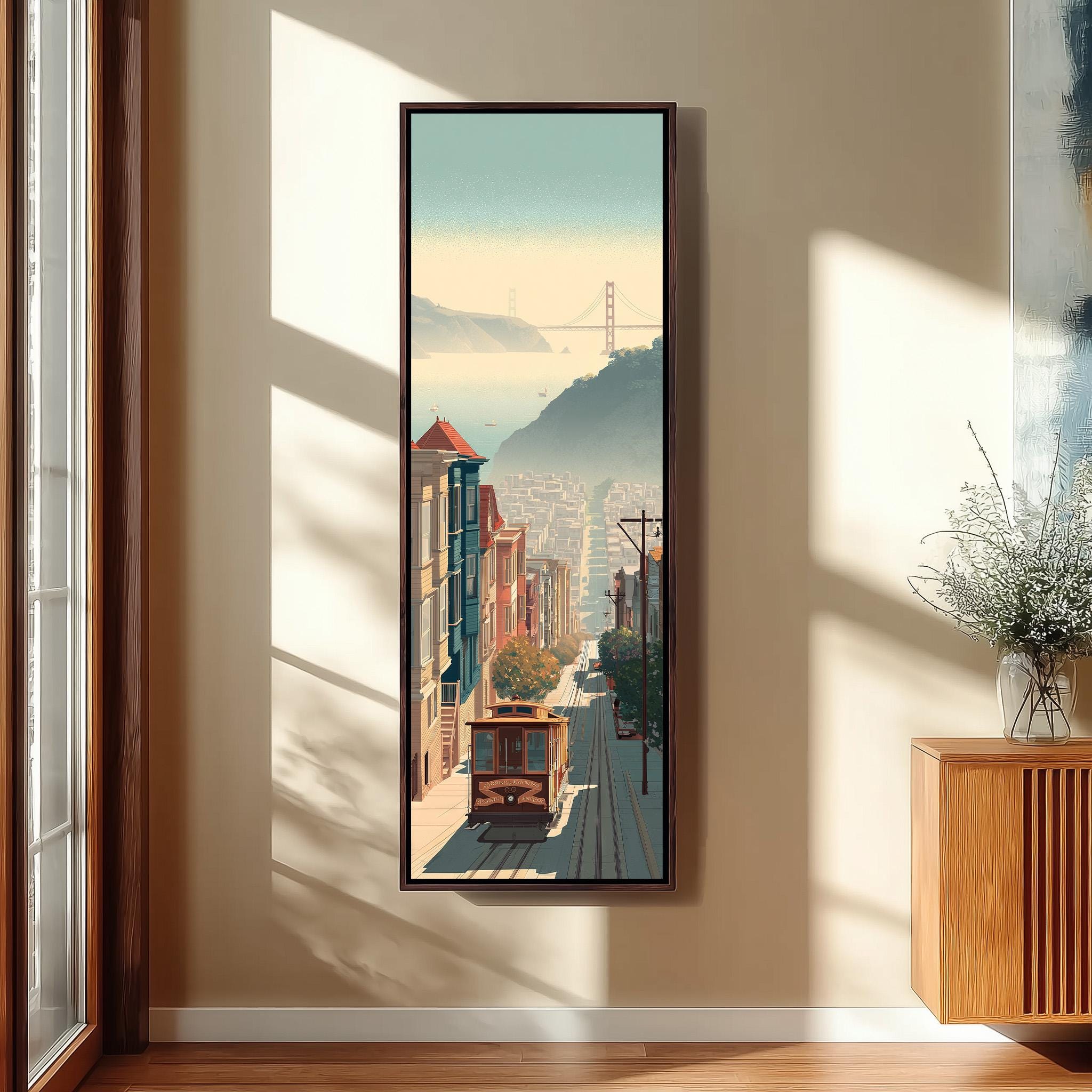 a framed painting of a cityscape with a trolley car in the foreground, hanging on a wall in a room with a window and a wooden cabinet.