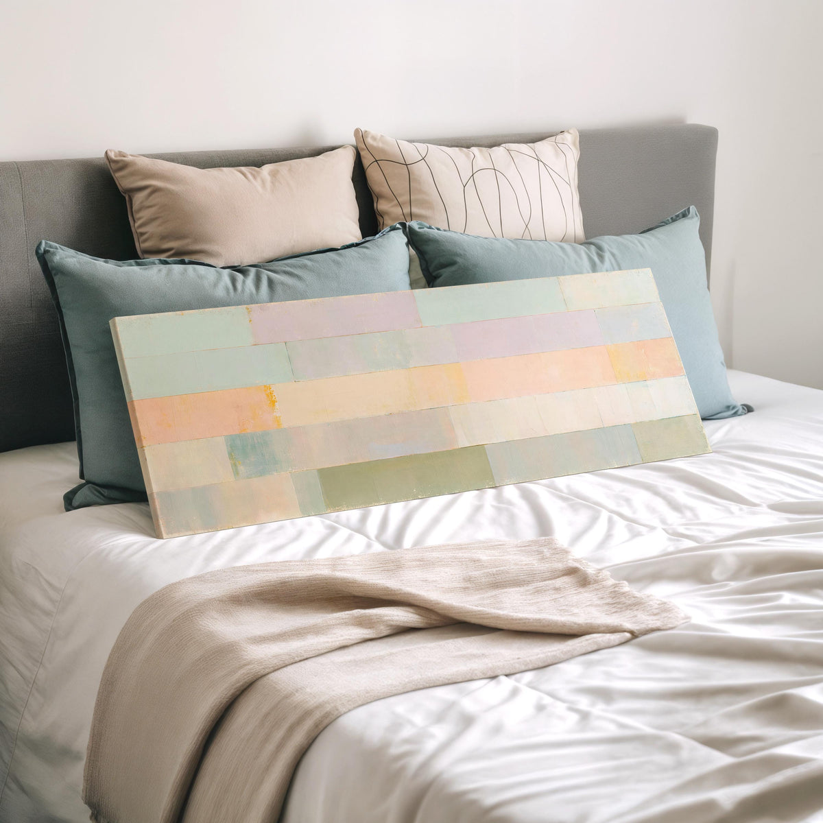 Soft lilac, mint and butter color bands wide panoramic canvas print laid on a bed to show its size