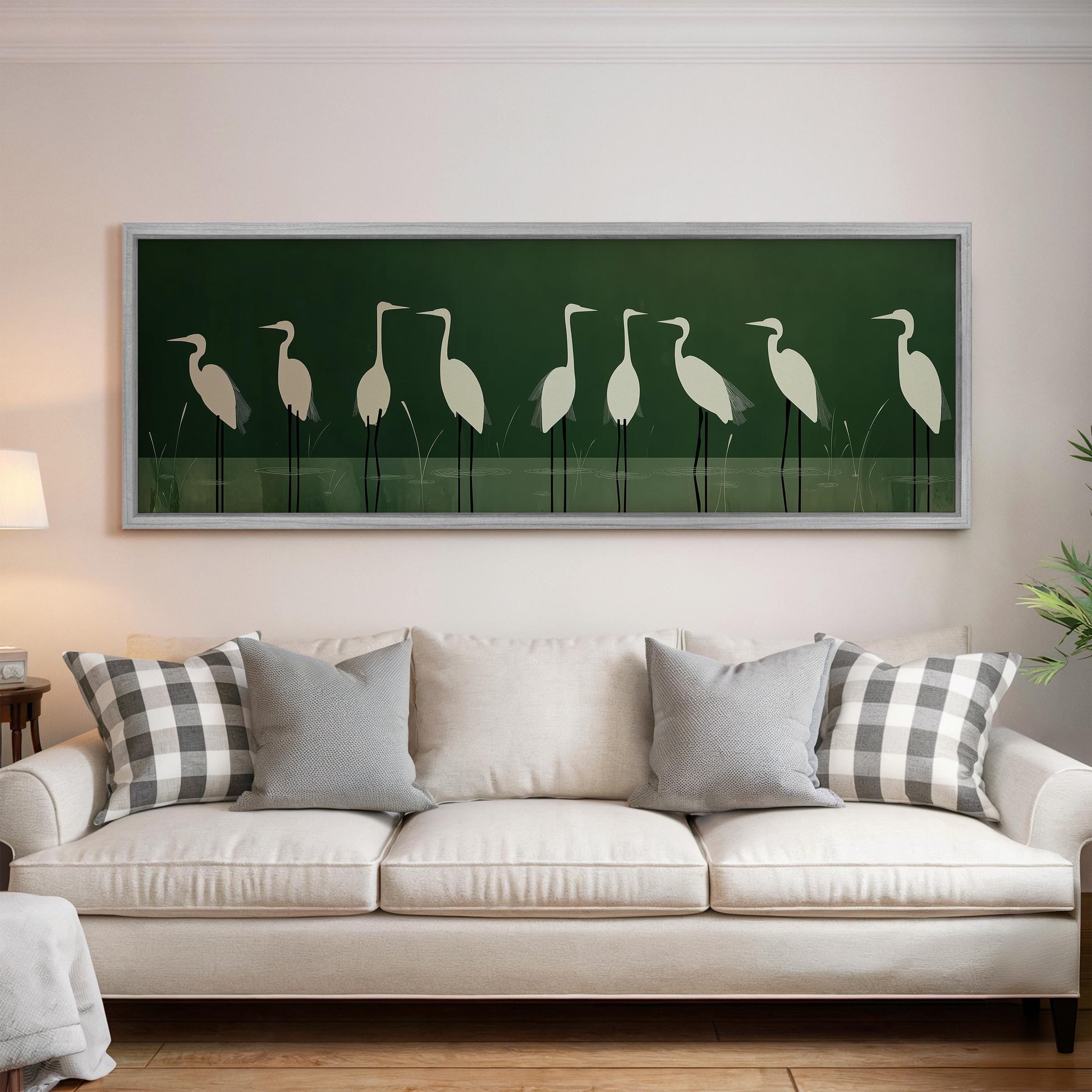 a living room with a white sofa and a framed artwork of white birds on the wall above it.