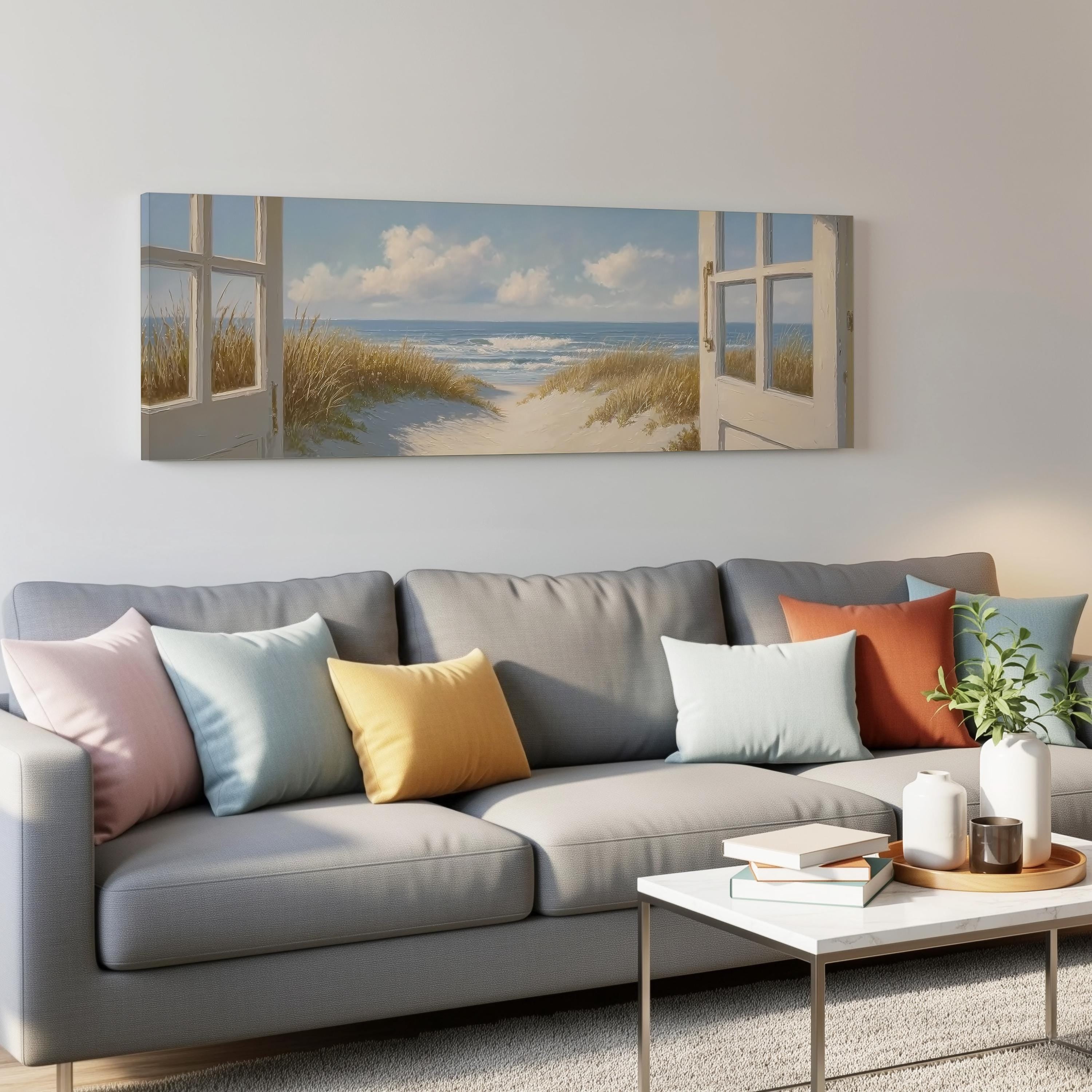 a living room with a gray sofa adorned with colorful throw pillows, a coffee table, and a painting of a beach scene hanging on the wall above the sofa.