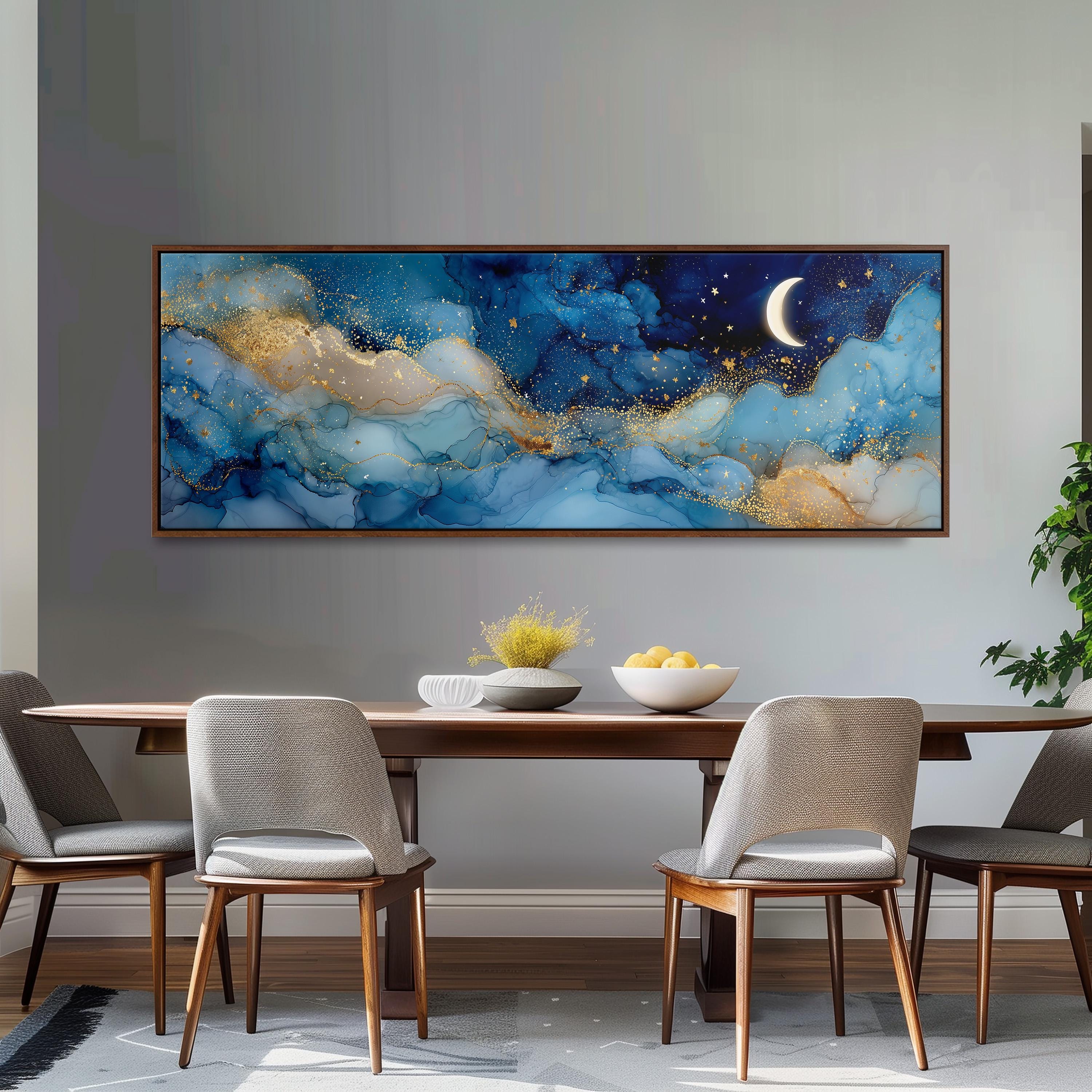 a large, framed painting of a night sky with a crescent moon and stars, hanging on a wall above a wooden dining table with four chairs.