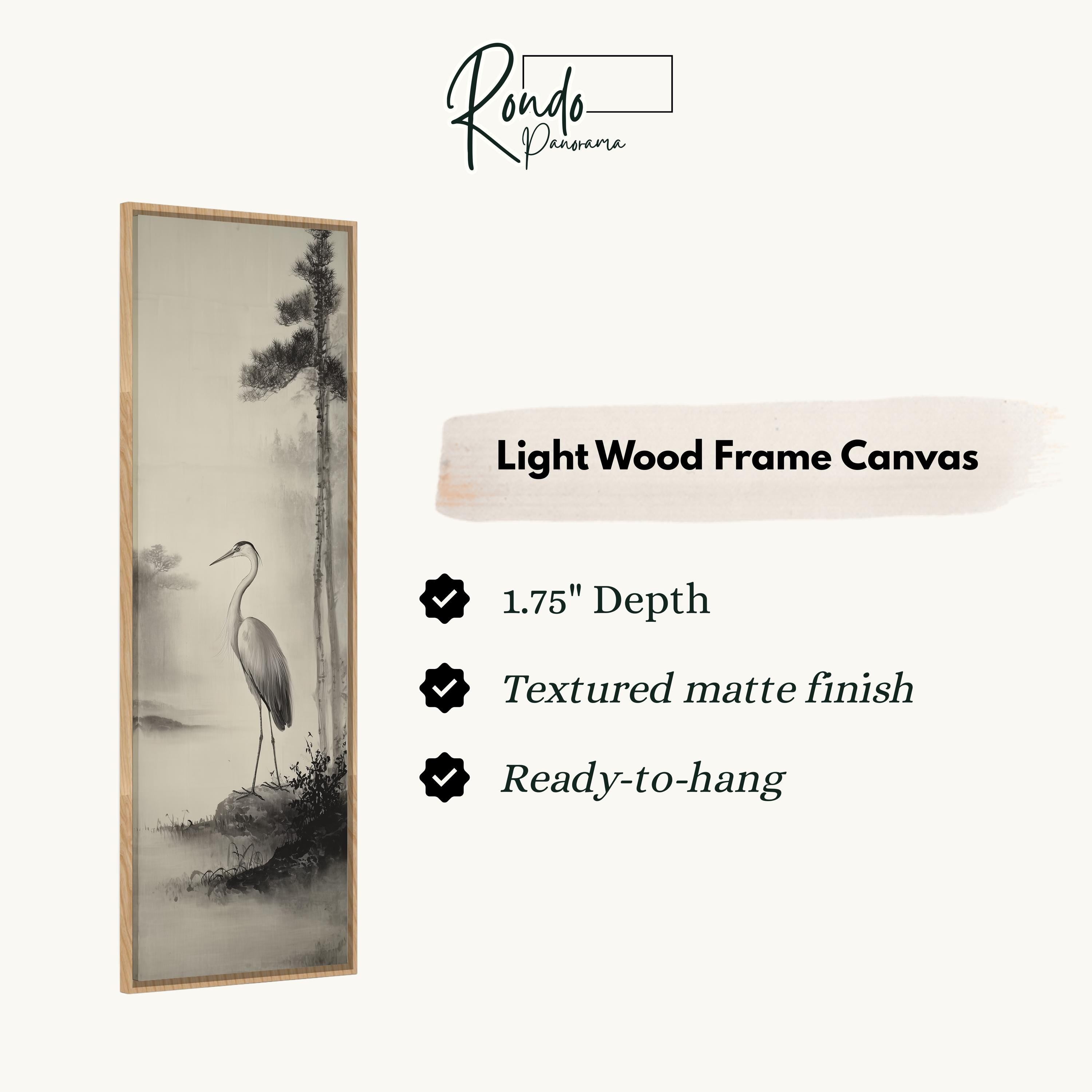 The image is a light wood frame canvas featuring a black and white image of a crane standing on a rocky shore.