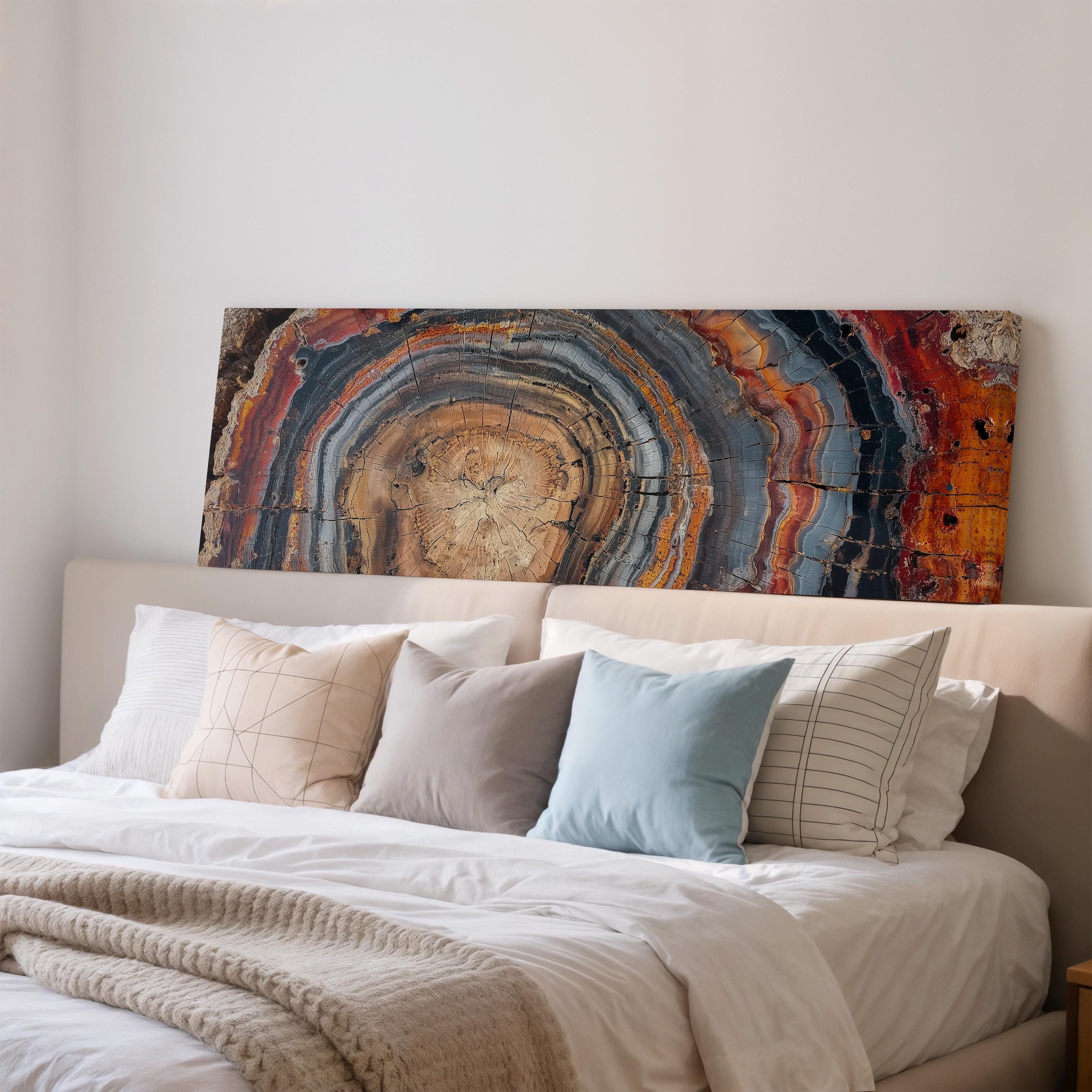 a large bed with a white headboard and a colorful abstract painting hanging above it.