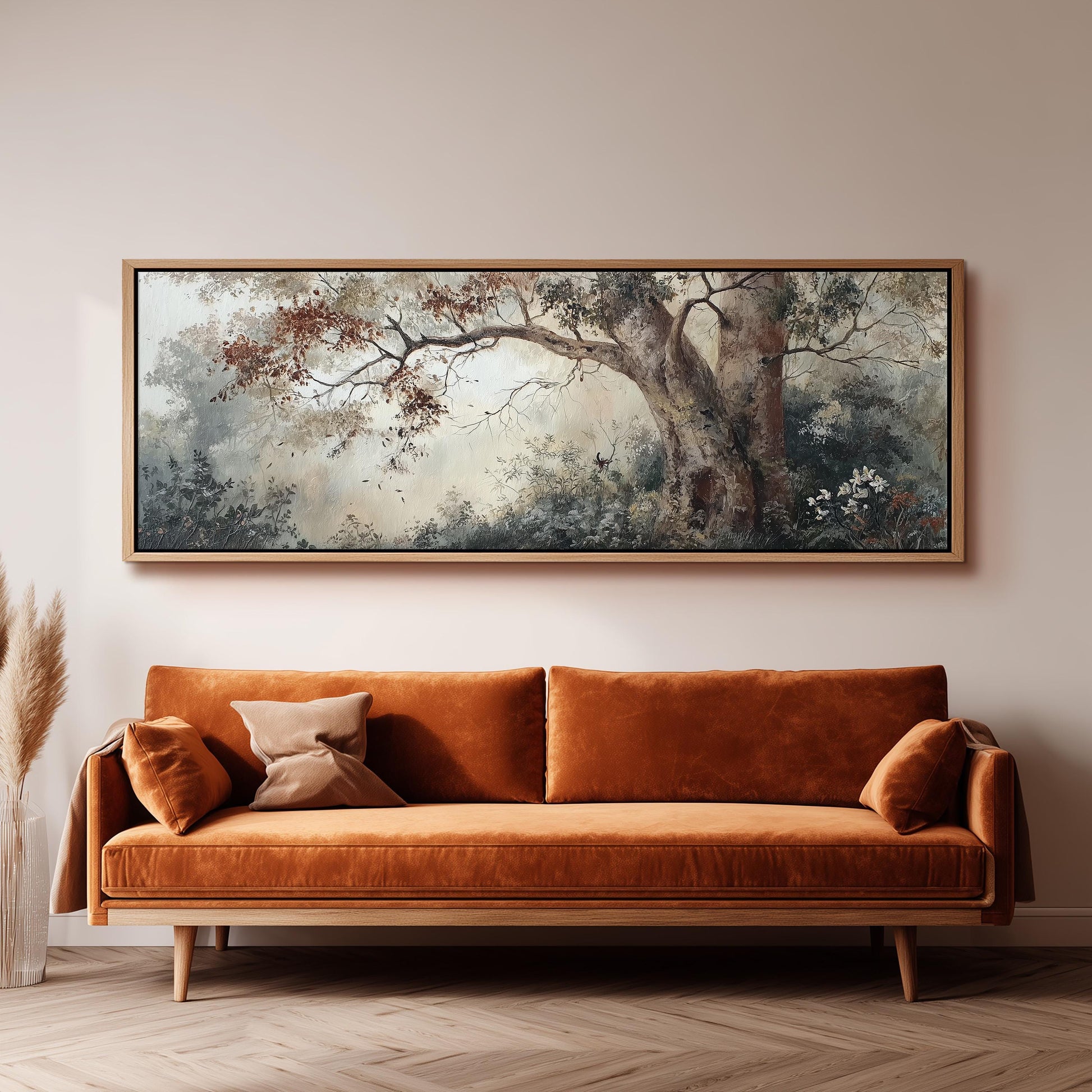 a large, framed painting of a tree with a forest scene hanging on a wall above a brown sofa with orange cushions.