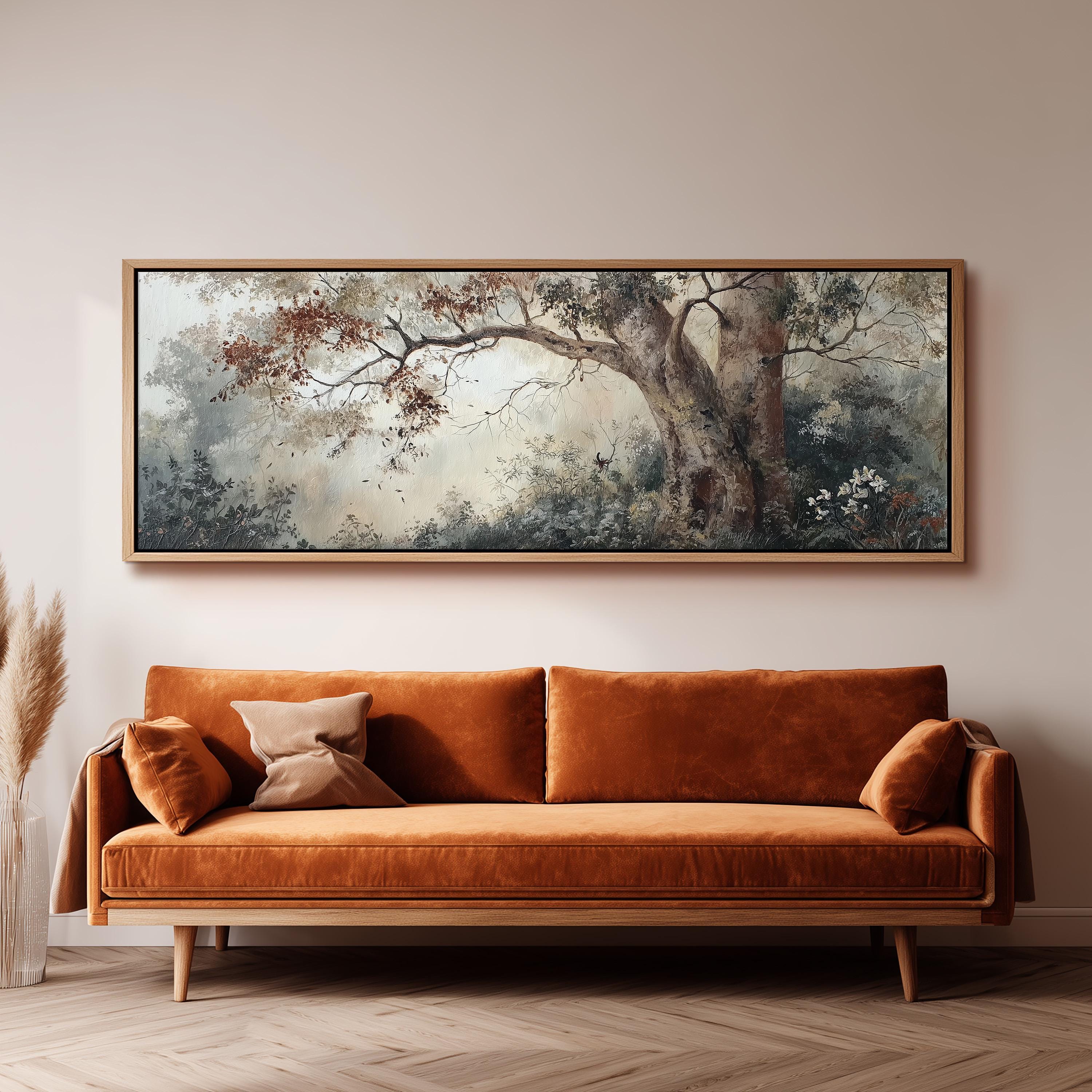 a large, framed painting of a tree with a forest scene hanging on a wall above a brown sofa with orange cushions.