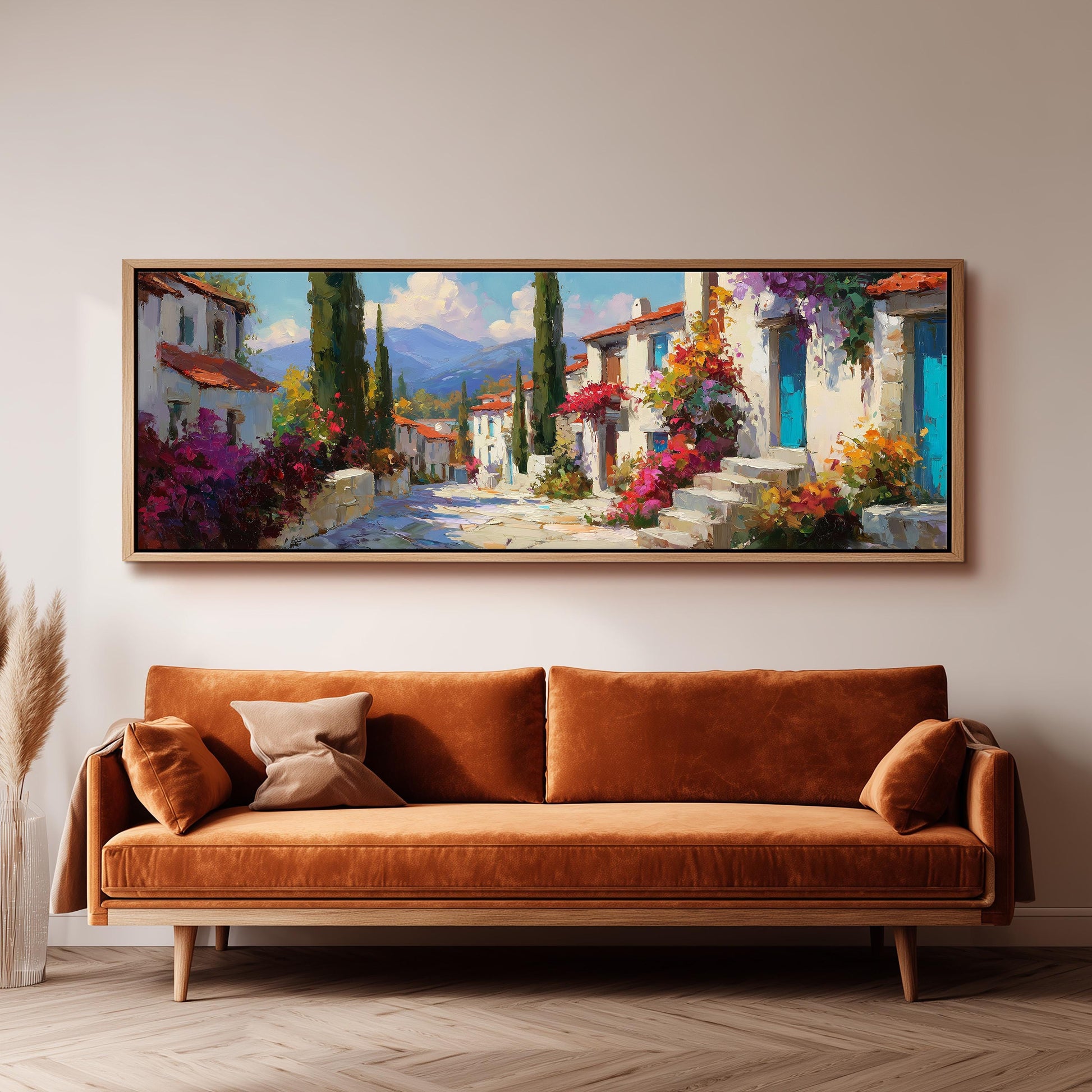a large, colorful painting of a picturesque village scene hanging on a wall above a brown sofa.