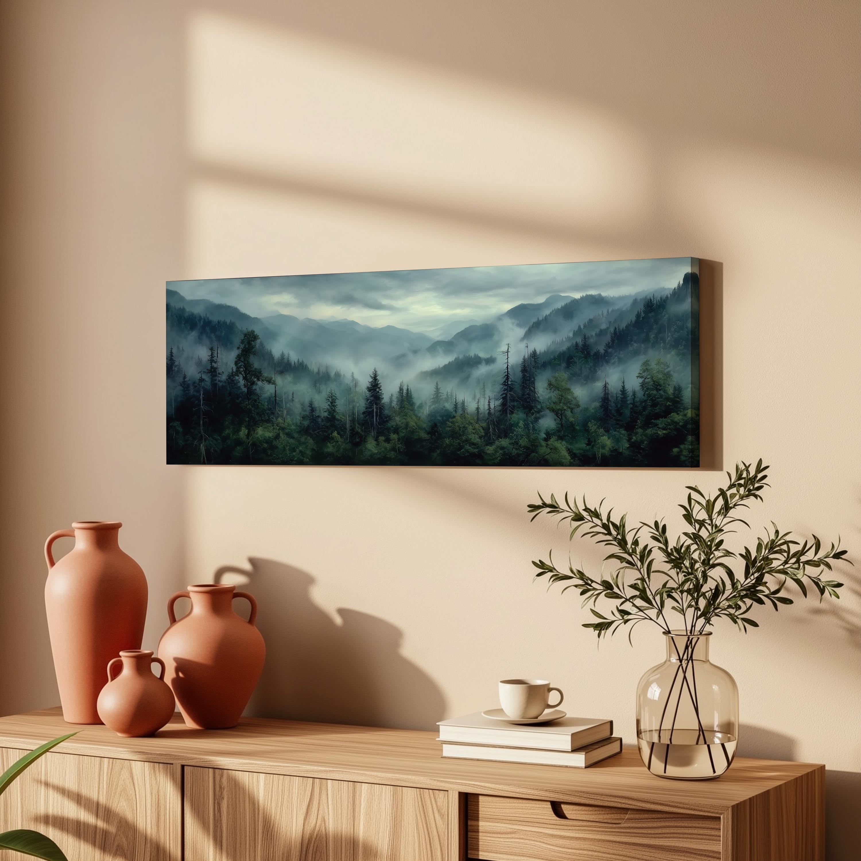 a wooden cabinet with a vase, a stack of books, and a plant on top. Above the cabinet, there is a framed landscape painting depicting a forest scene with mountains and a misty atmosphere.