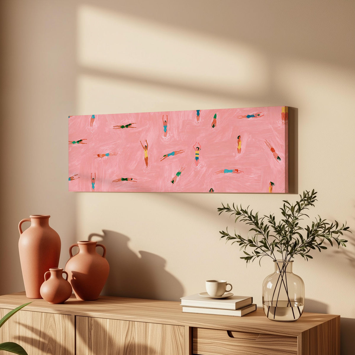 Tiny swimmers in a pink pool from above long horizontal canvas print above a wooden sideboard