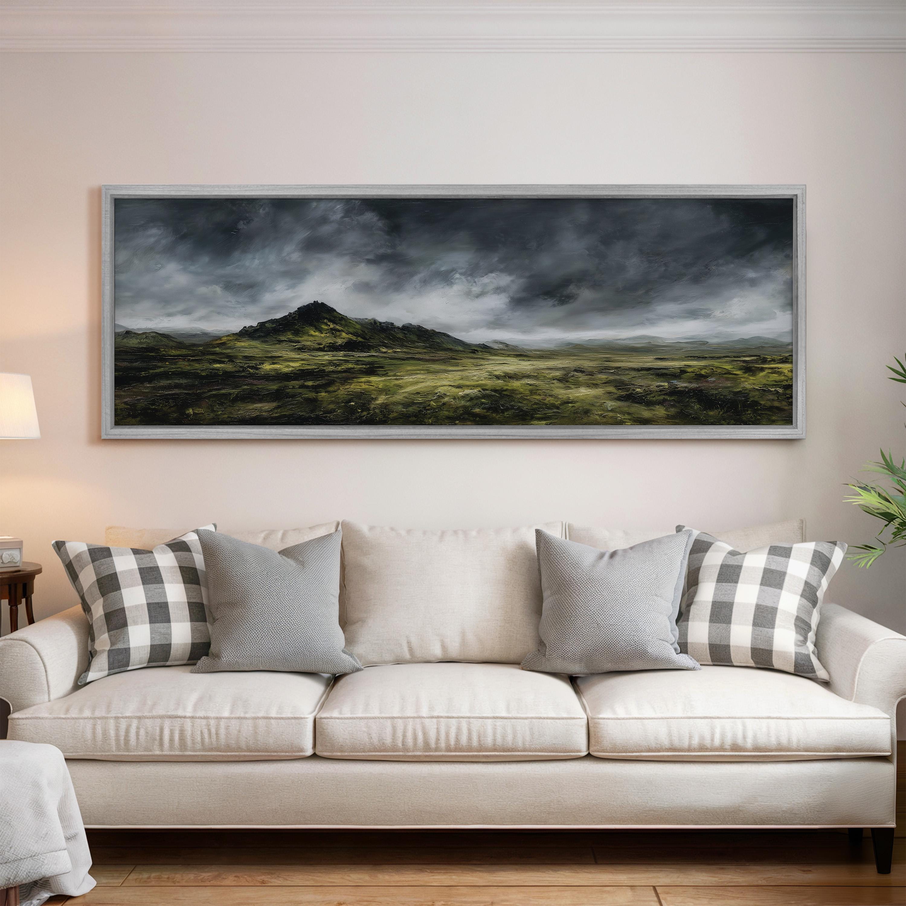 a large landscape painting hanging on a wall above a white sofa with gray and white plaid throw pillows.