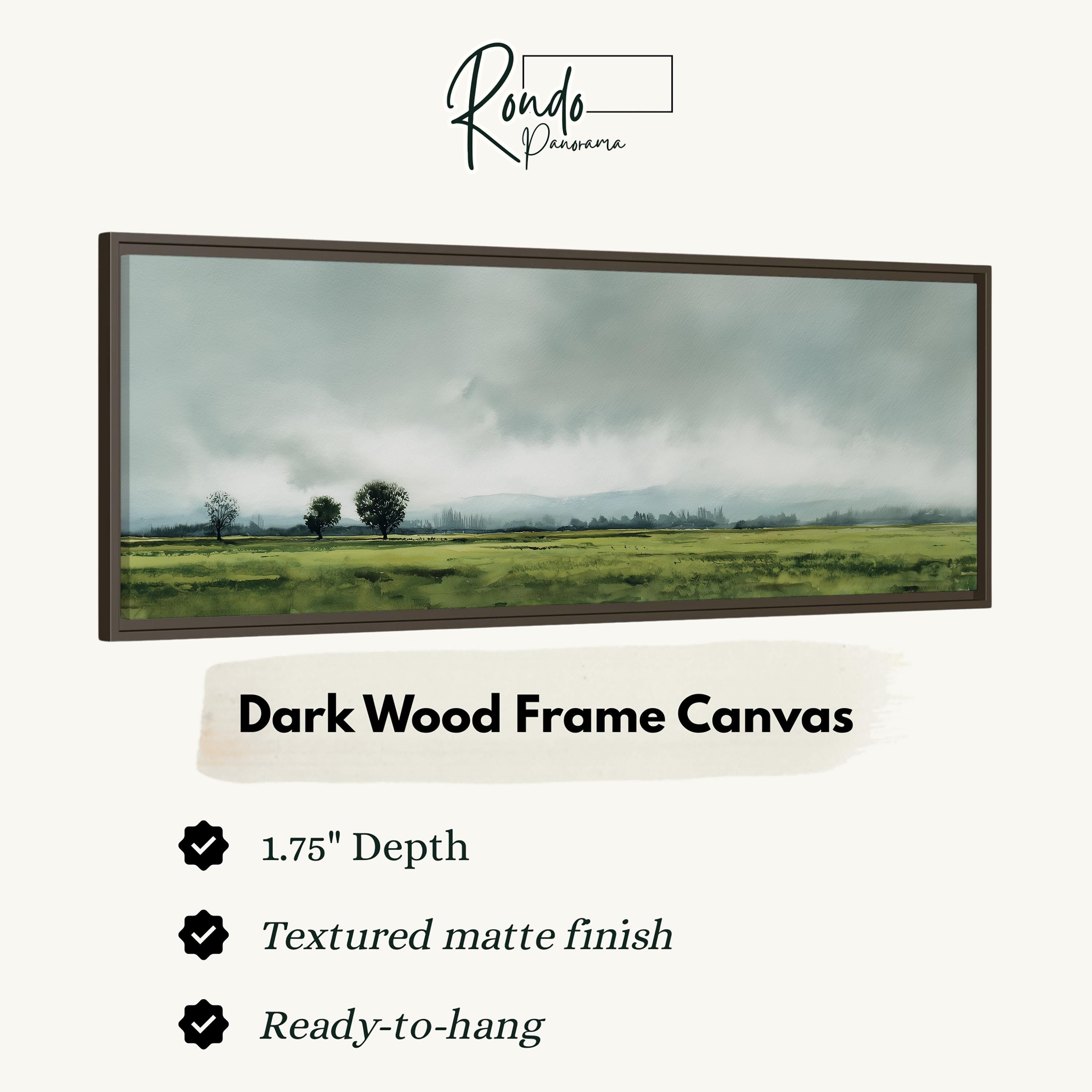 The image is a dark wood frame canvas depicting a rural landscape with a field and trees under a cloudy sky.