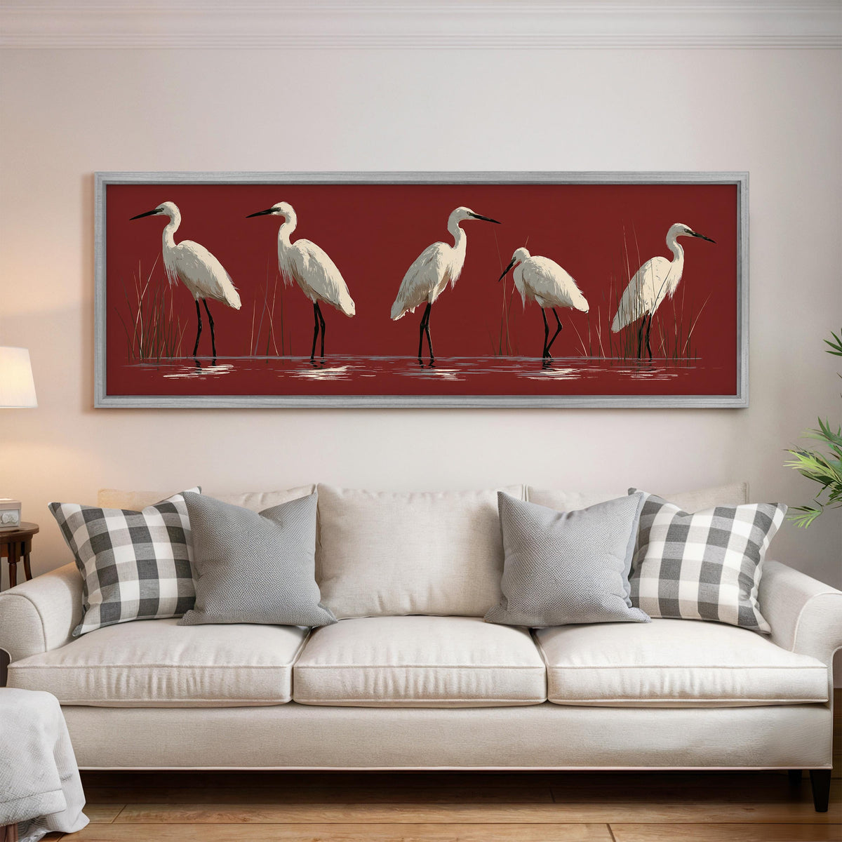 White egrets wading on crimson red panoramic canvas print above a white sofa in a bright living room