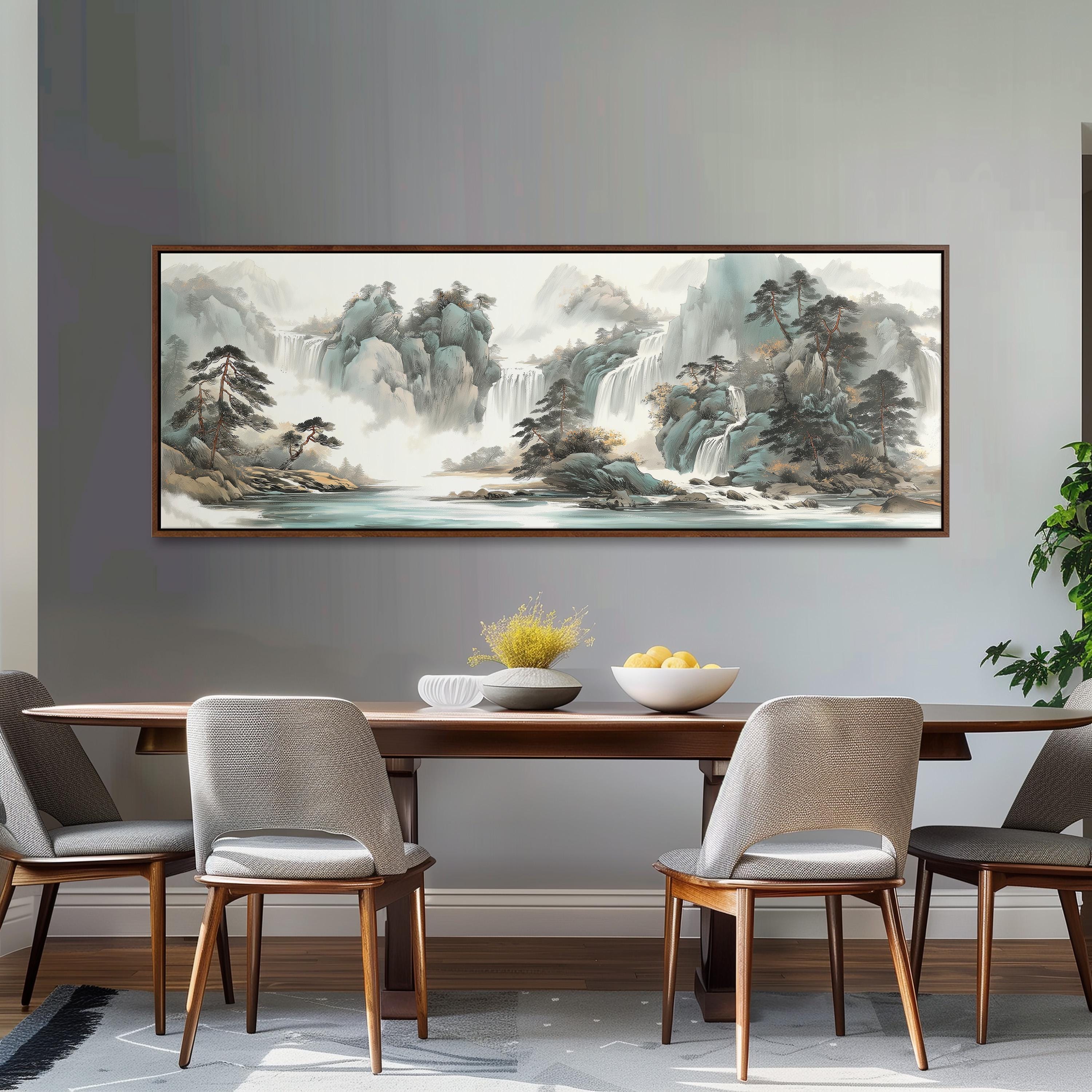 a large landscape painting hanging on a wall above a wooden dining table with four chairs. The painting depicts a serene mountain scene with a waterfall, creating a peaceful and inviting atmosphere.