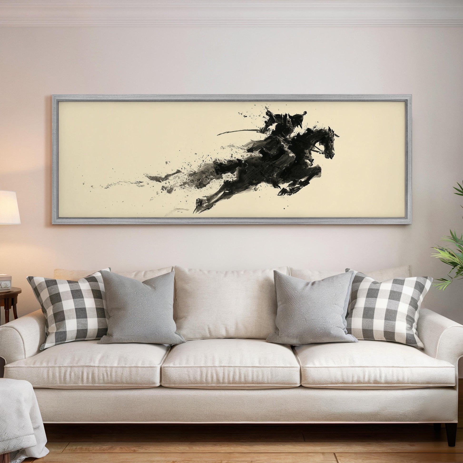 a large, framed artwork of a horse and rider on a wall above a white couch with gray and white plaid throw pillows.
