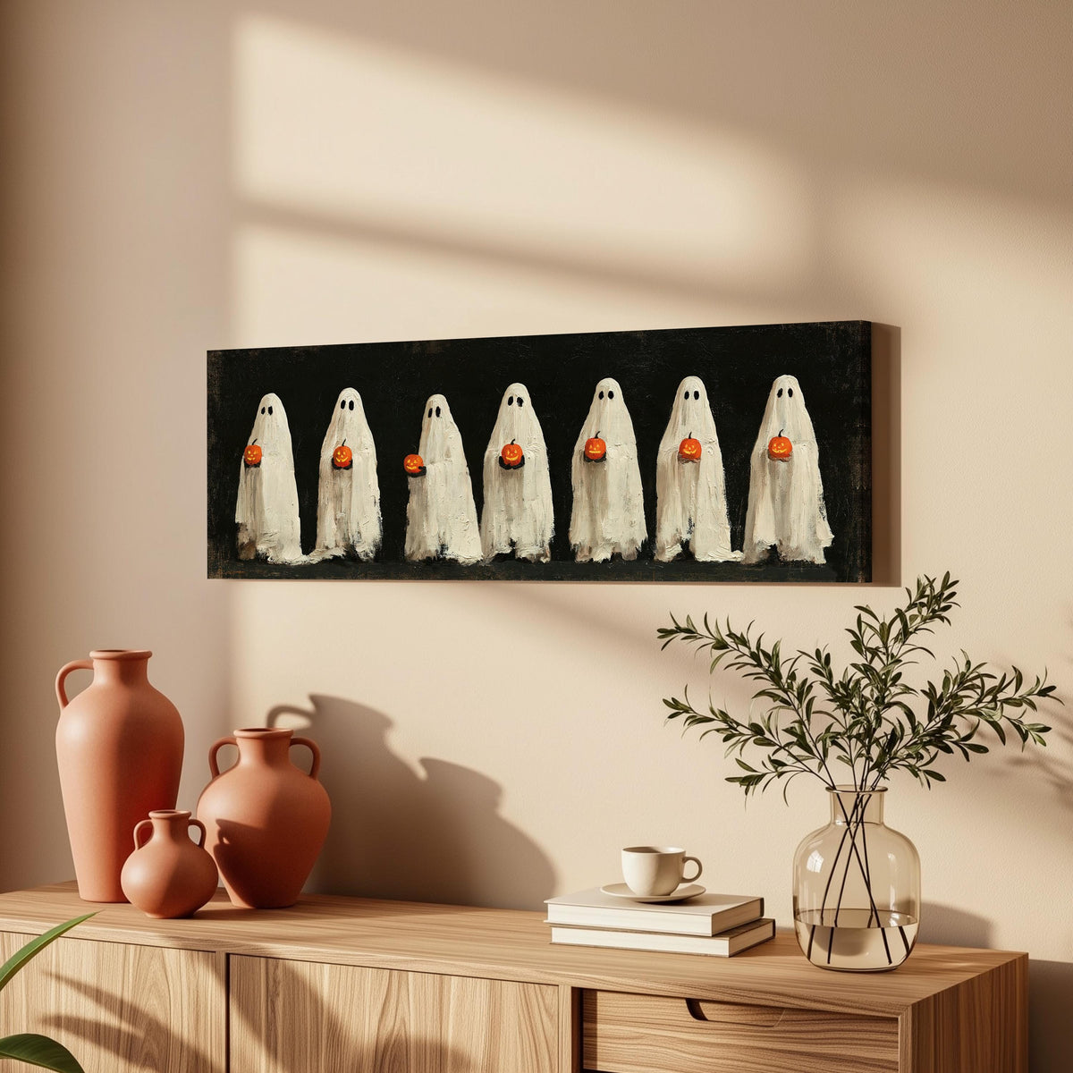 Row of ghosts holding pumpkins long horizontal canvas print above a wooden sideboard