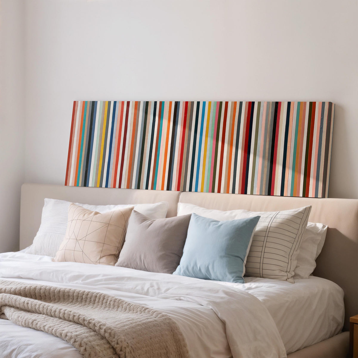 Rainbow pinstripes wide panoramic canvas print above a bed in a bedroom