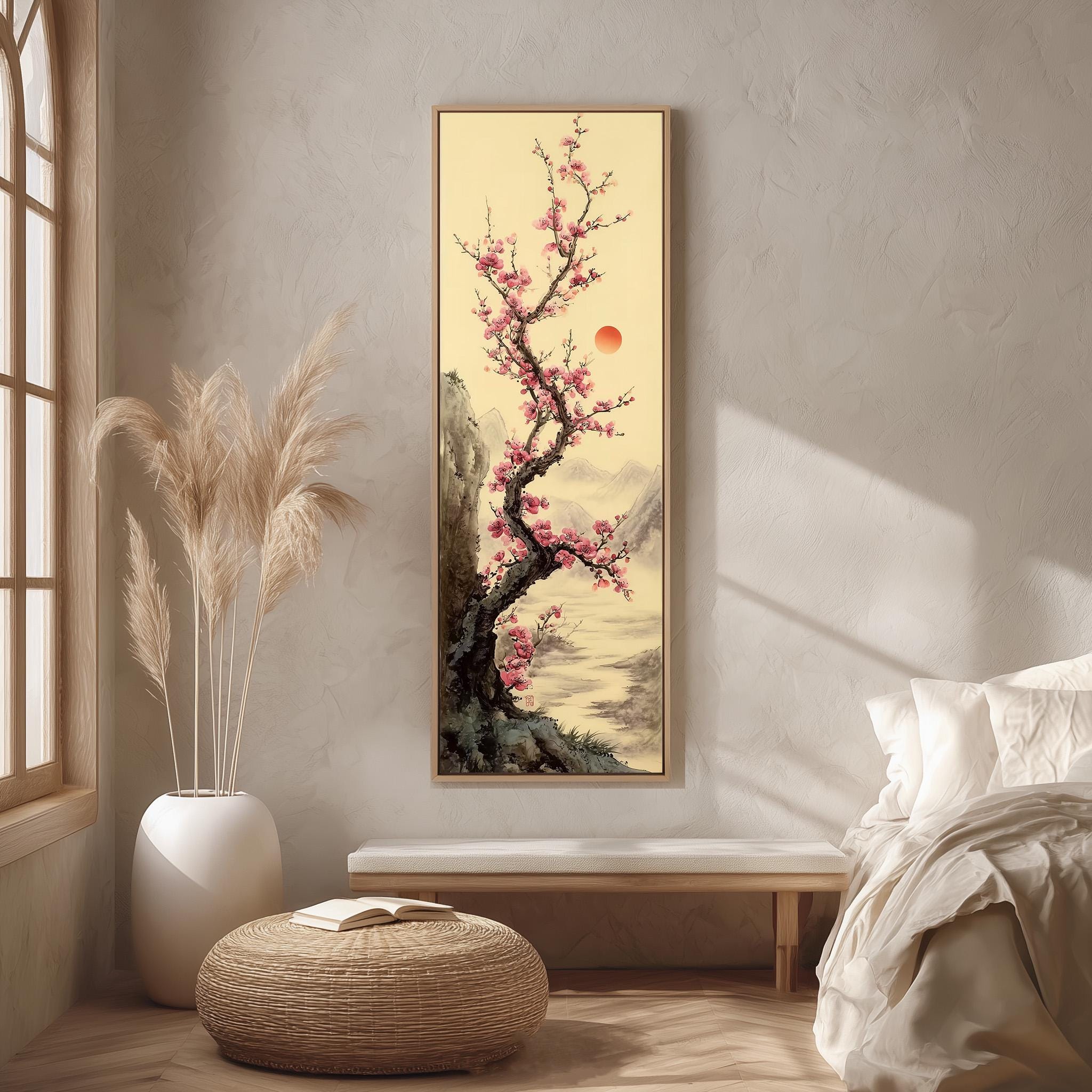 a serene bedroom scene with a large painting of a cherry blossom tree hanging on the wall, a white bed with a white pillow, a white vase with dried flowers, and a woven ottoman.
