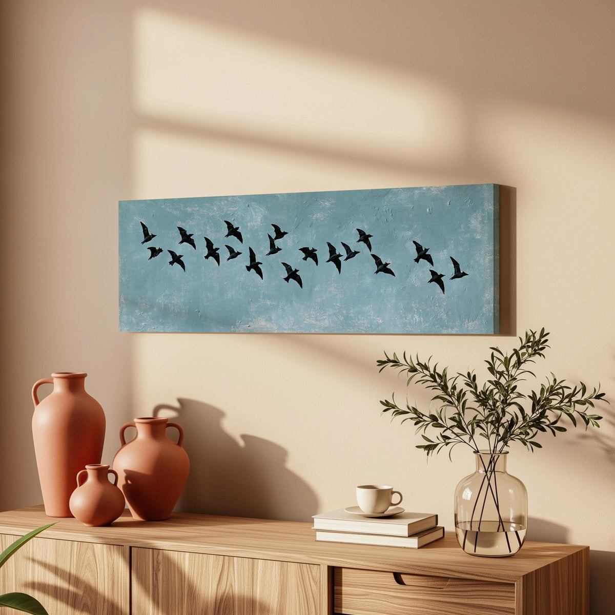 Flock of black birds on a teal sky long horizontal canvas print above a wooden sideboard