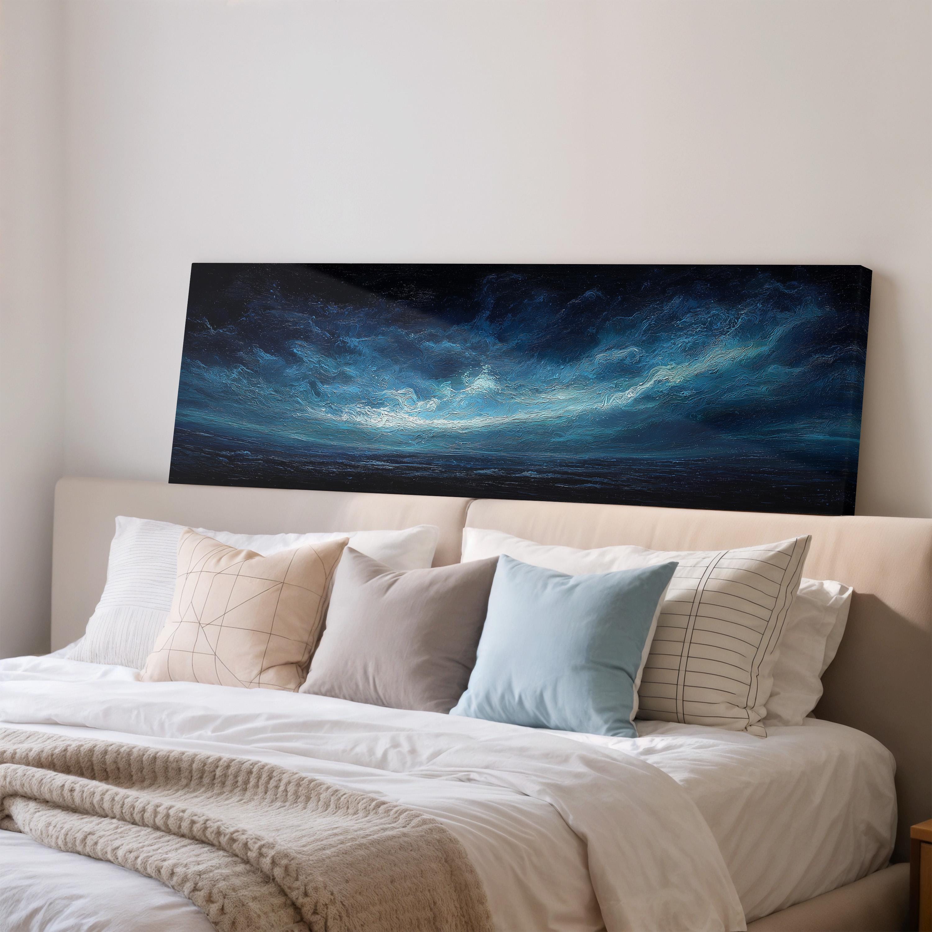 a large, dark-toned painting of a stormy ocean scene displayed on a wall above a bed with white bedding and pillows.