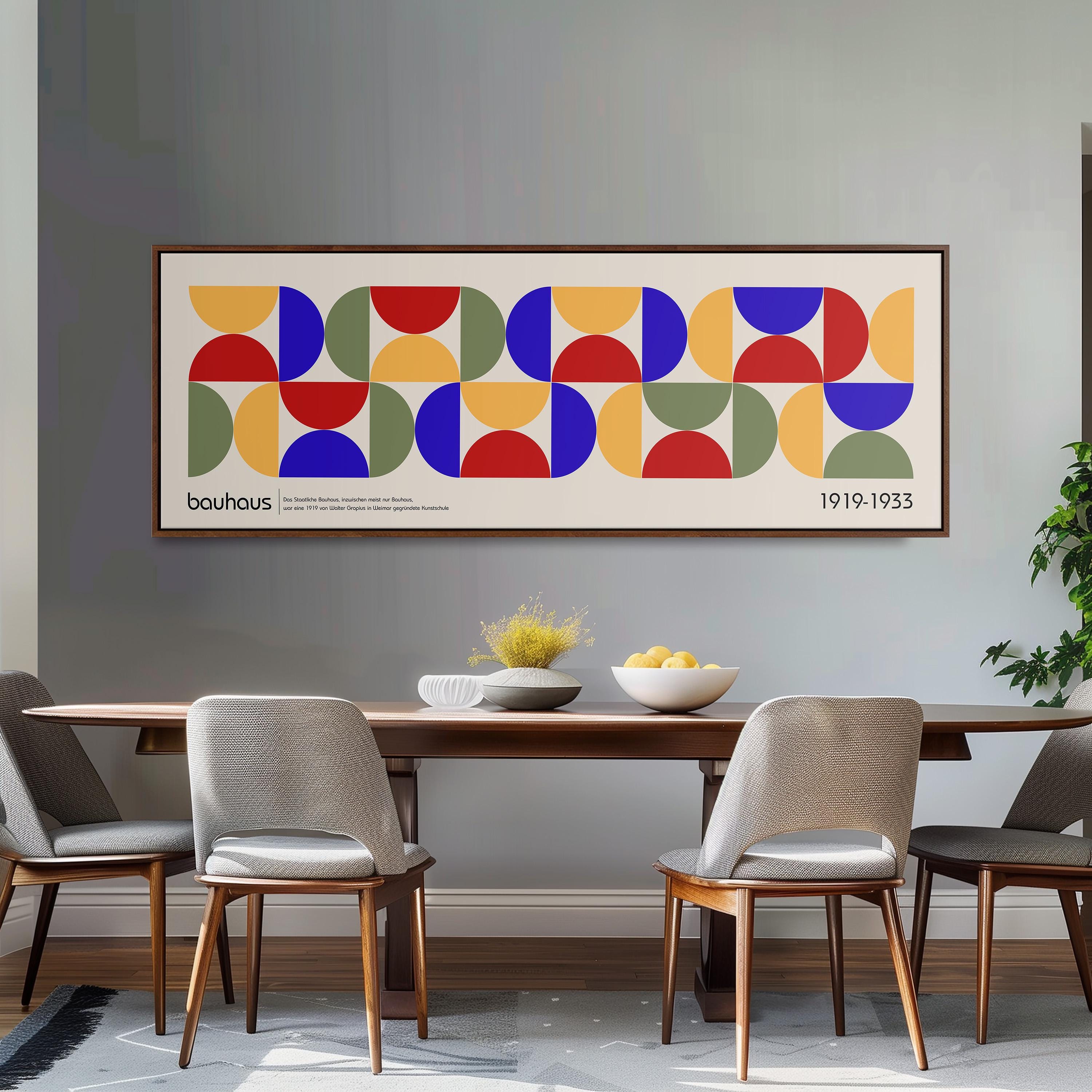 a dining room with a large abstract painting hanging on the wall above a wooden table with four chairs. The painting consists of a series of colorful geometric shapes, creating a vibrant and modern design.