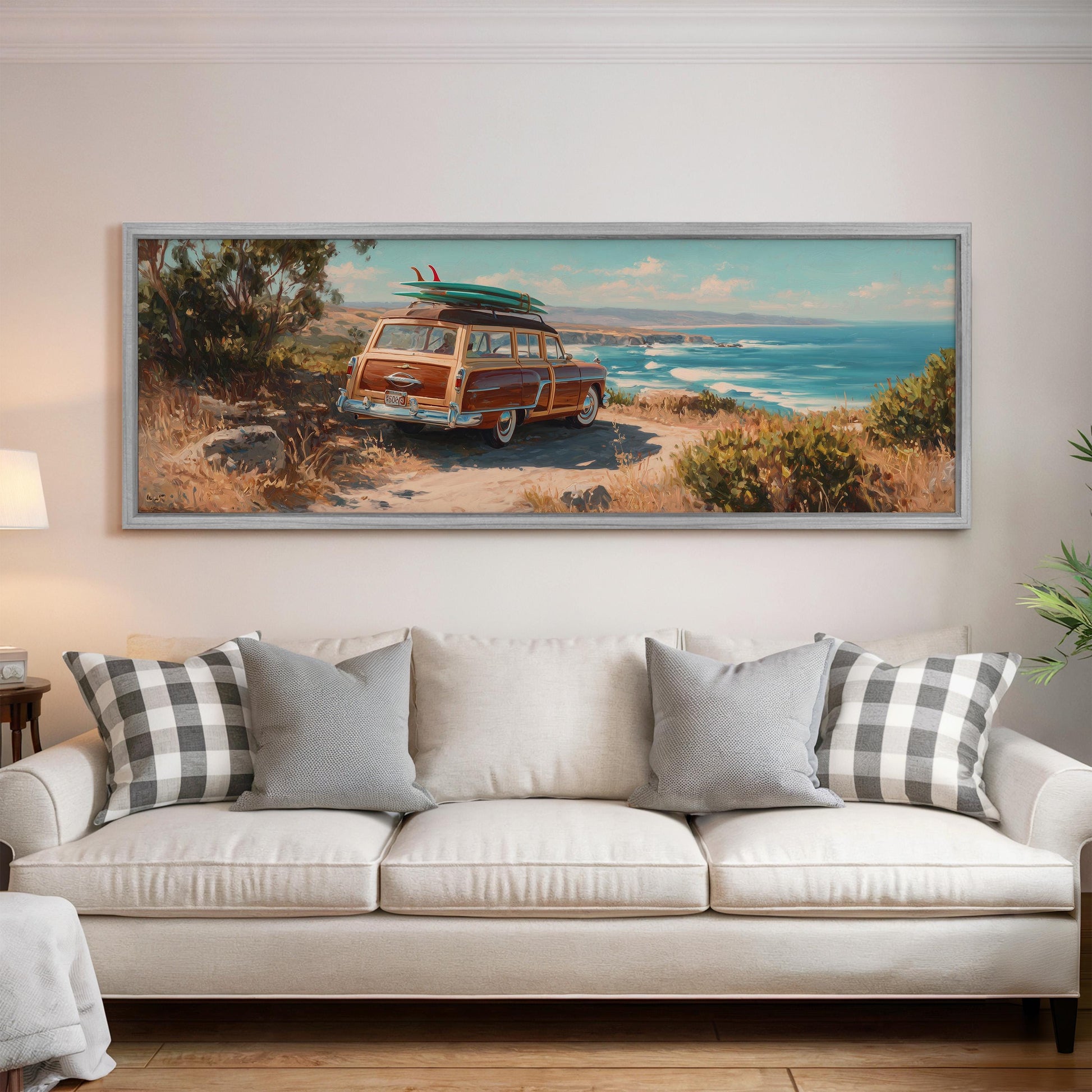 a large painting of a vintage car with a surfboard on top, displayed on a wall above a white couch in a living room setting.