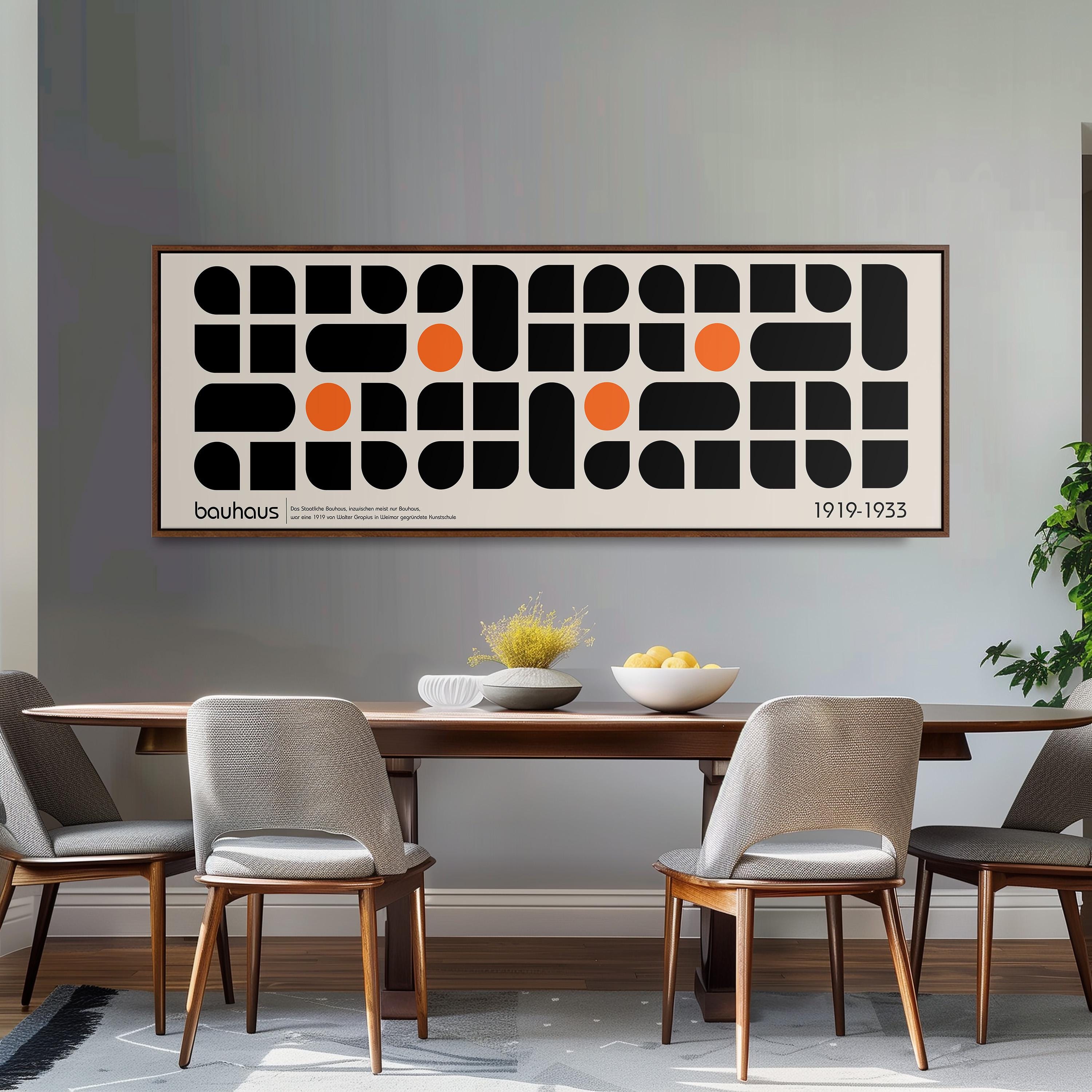 a dining room with a wooden table and four chairs. Above the table, there is a large abstract art piece with black and orange shapes. The art piece is framed and hangs on the wall above the table.
